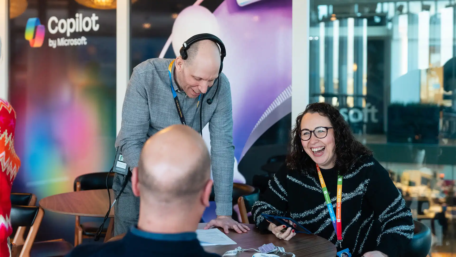 Production team coordinating with presenters during a live Microsoft broadcast, capturing relaxed, conversational moments on set.
