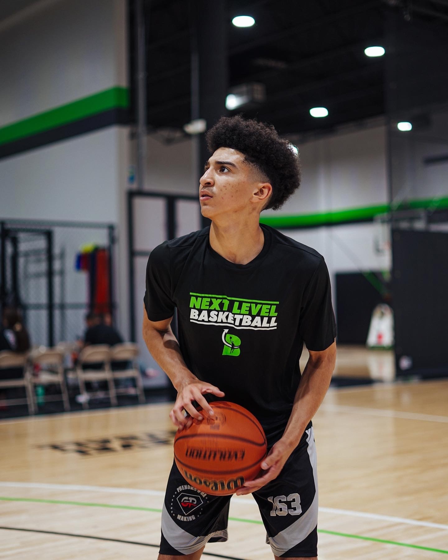 A woman stands in an office, with social media icons emerging from her laptop, symbolizing digital connectivity and engagement.