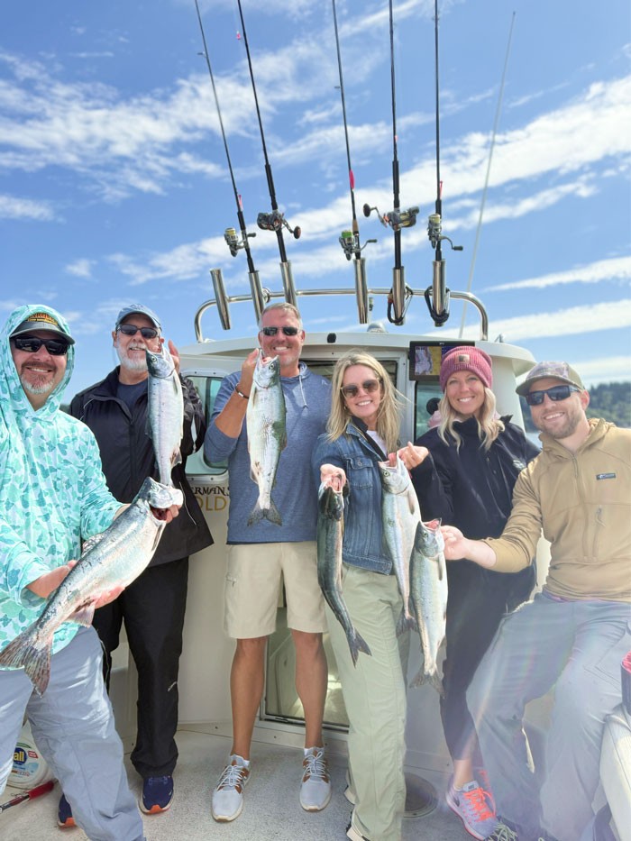 party of six holding salmon at a seattle fishing charter boat