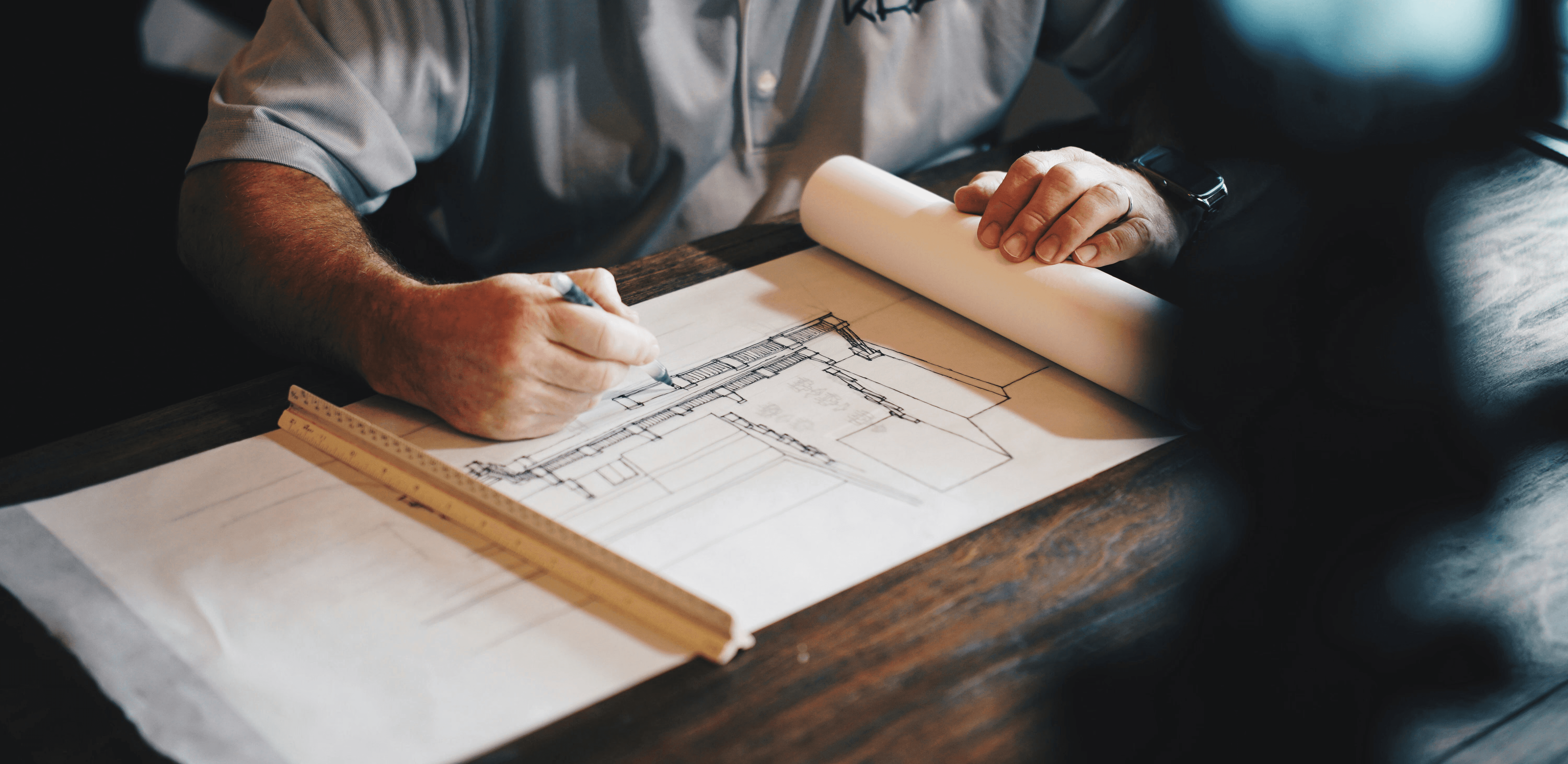 An architect working on a draft with a pencil and ruler