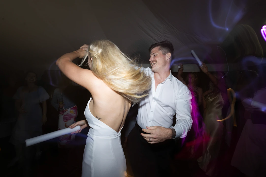 Groom spinnng bride around dancing