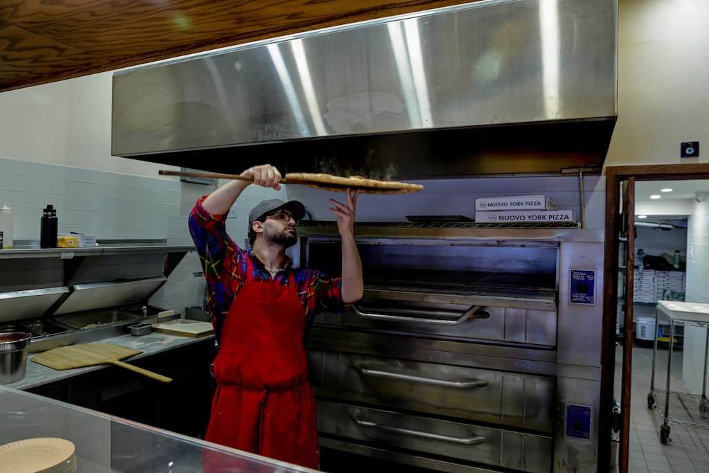 a man standing in front of a counter preparing food