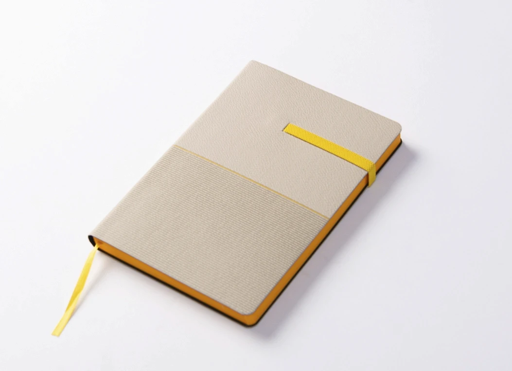 Angled view of two-tone textured journal with yellow edge detail