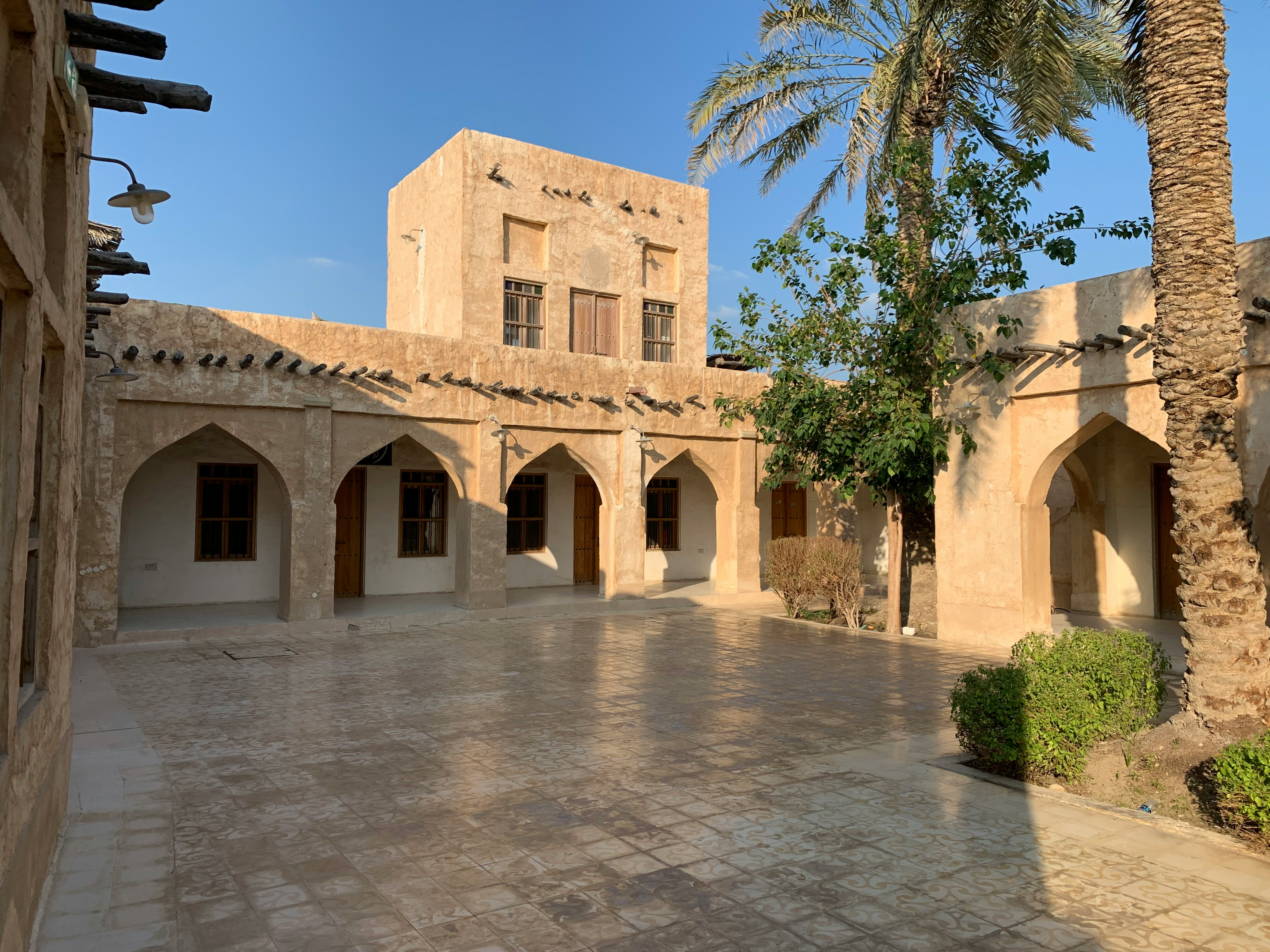 a courtyard with a palm tree in the middle