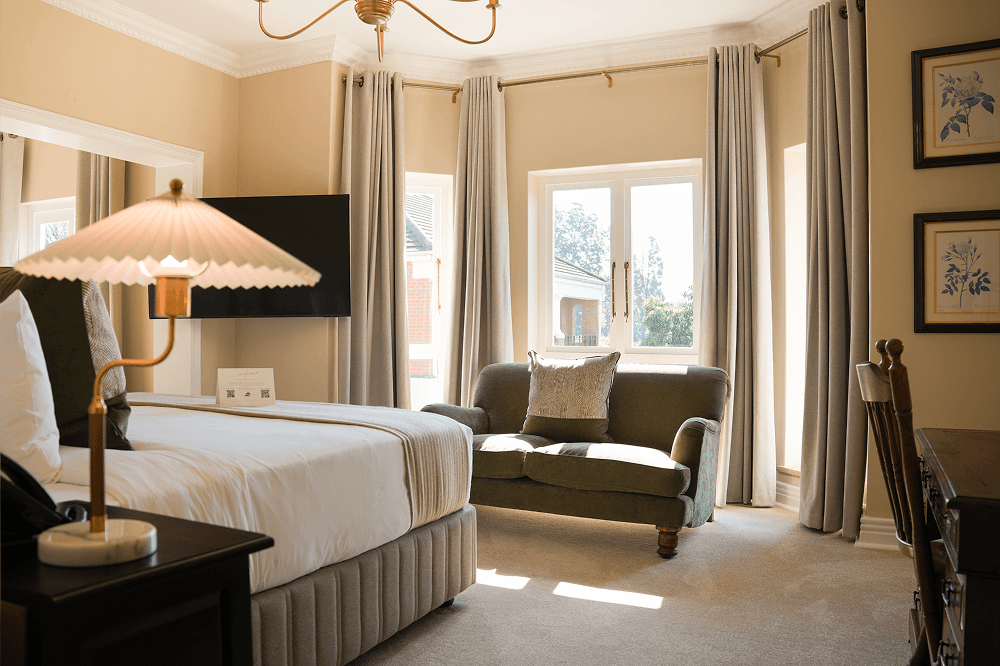 Elegant bedroom in Executive Suite with king-size bed and estate views.