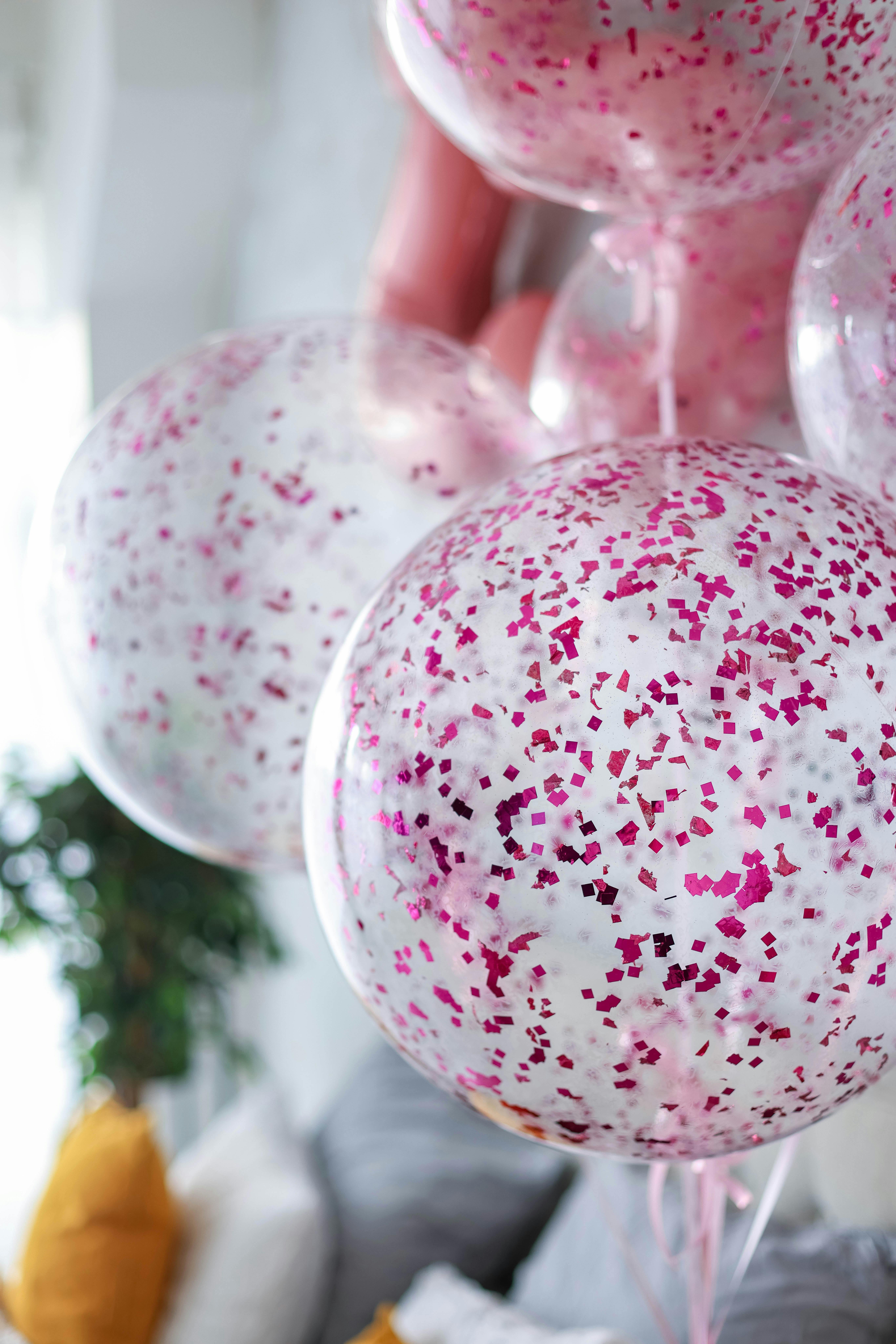 Pink confetti-filled balloon decoration next to sparkling drinks designed for a festive event