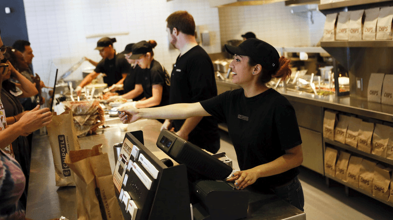 An image of a Chipotle cashier taking a customer's payment.