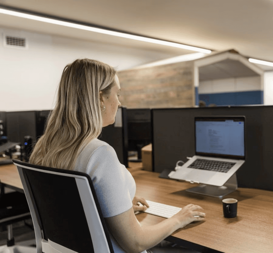 a woman sitting at the coworking desk at the crate north shore, working on her computer