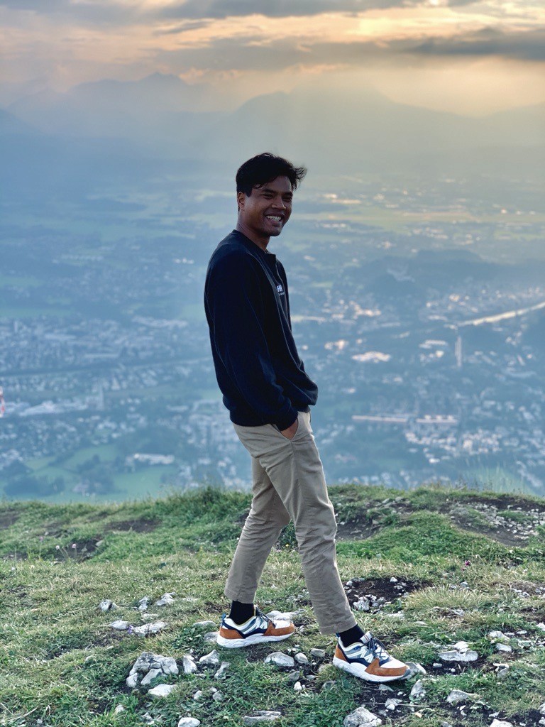 Daniel standing on the top of a mountain