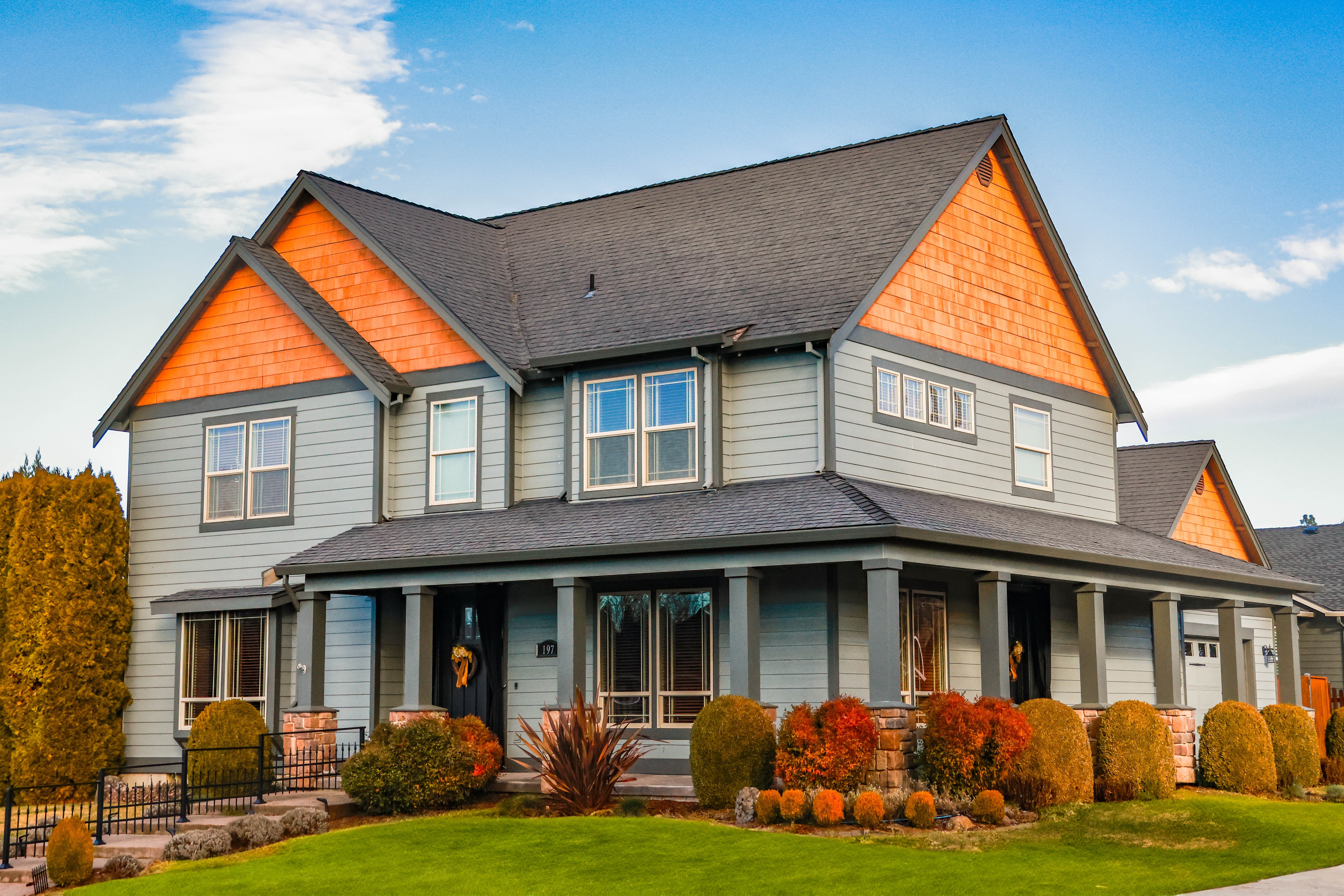 A Lewis Homes exterior with warm gables, landscaped gardens, and a broad roofline.