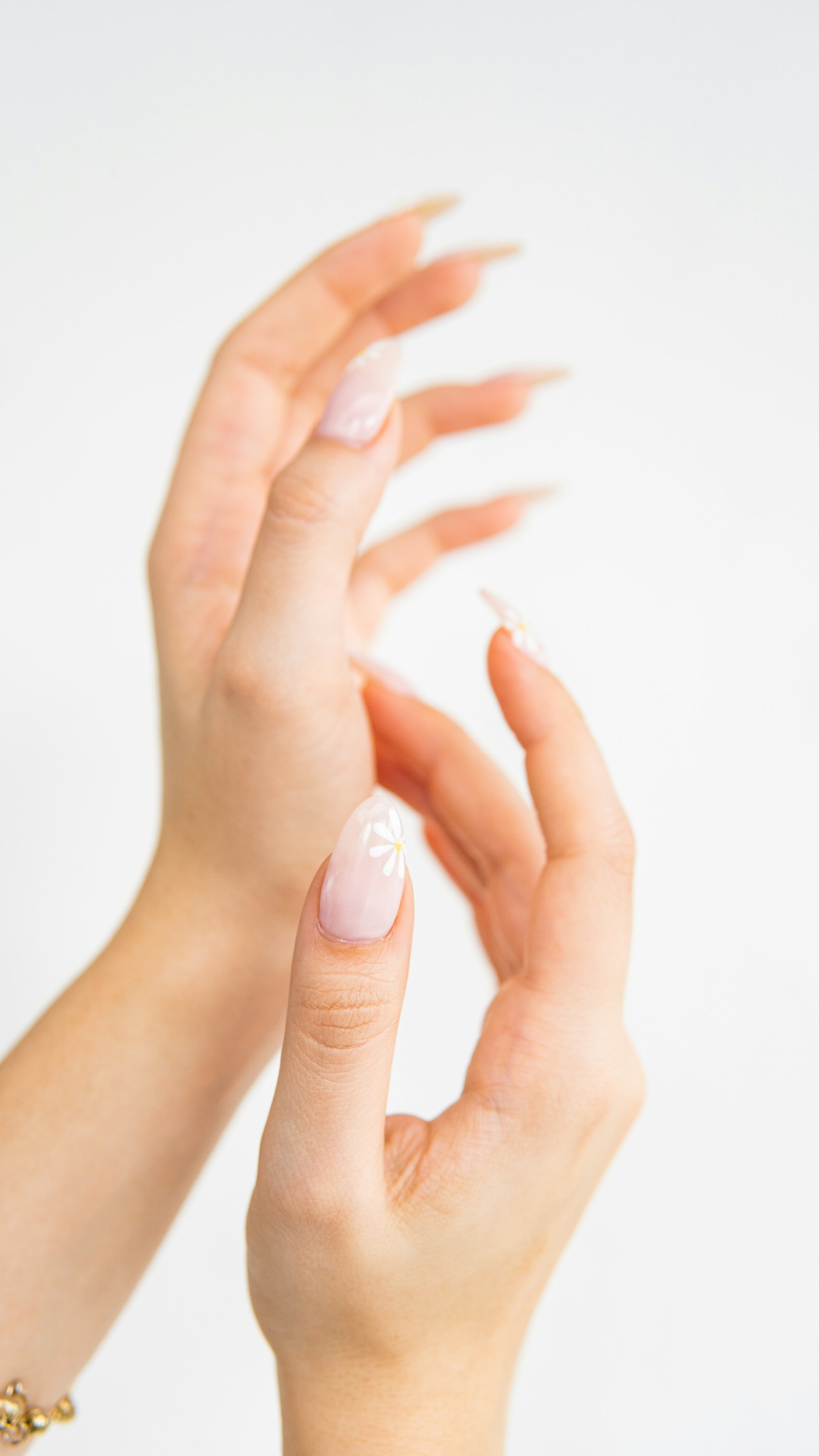 Mãos femininas com unhas recém-feitas em esmaltaria.