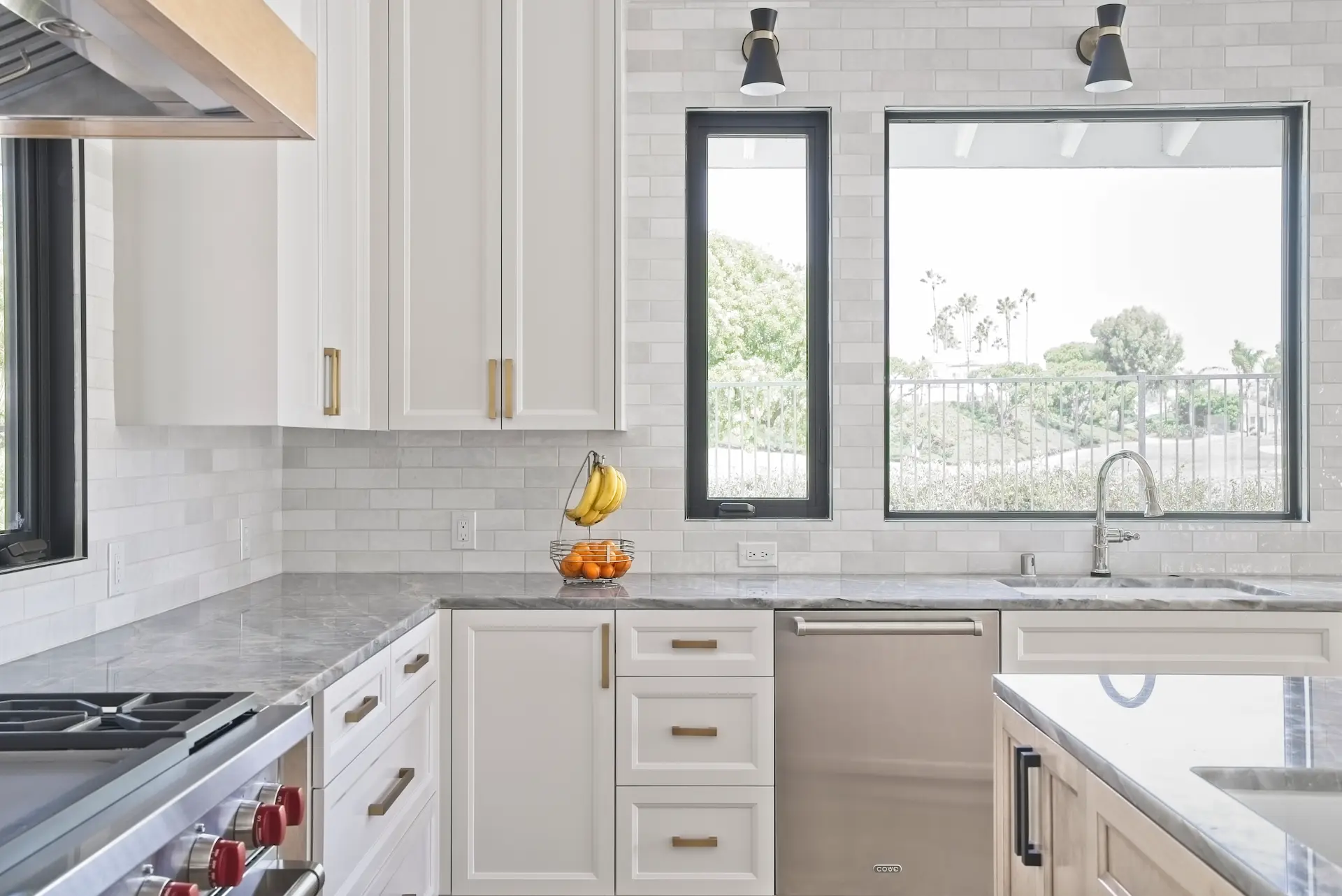 Close-up shot facing the kitchen sink, revealing the dishwasher and elegant custom cabinetry, a testament to the luxurious yet practical design in the Dana Point Full Remodel. Photo by Todd Huge.