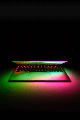 black laptop computer turned on in dim light