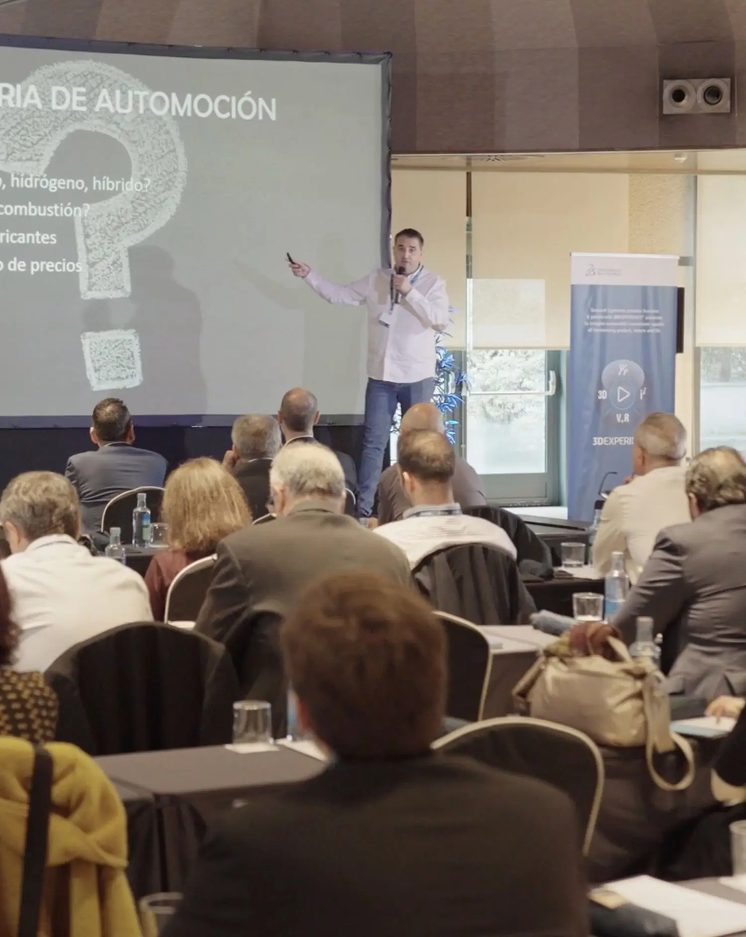 Portfolio Thankium: Conferencia sobre la industria de automoción con presentador y asistentes.