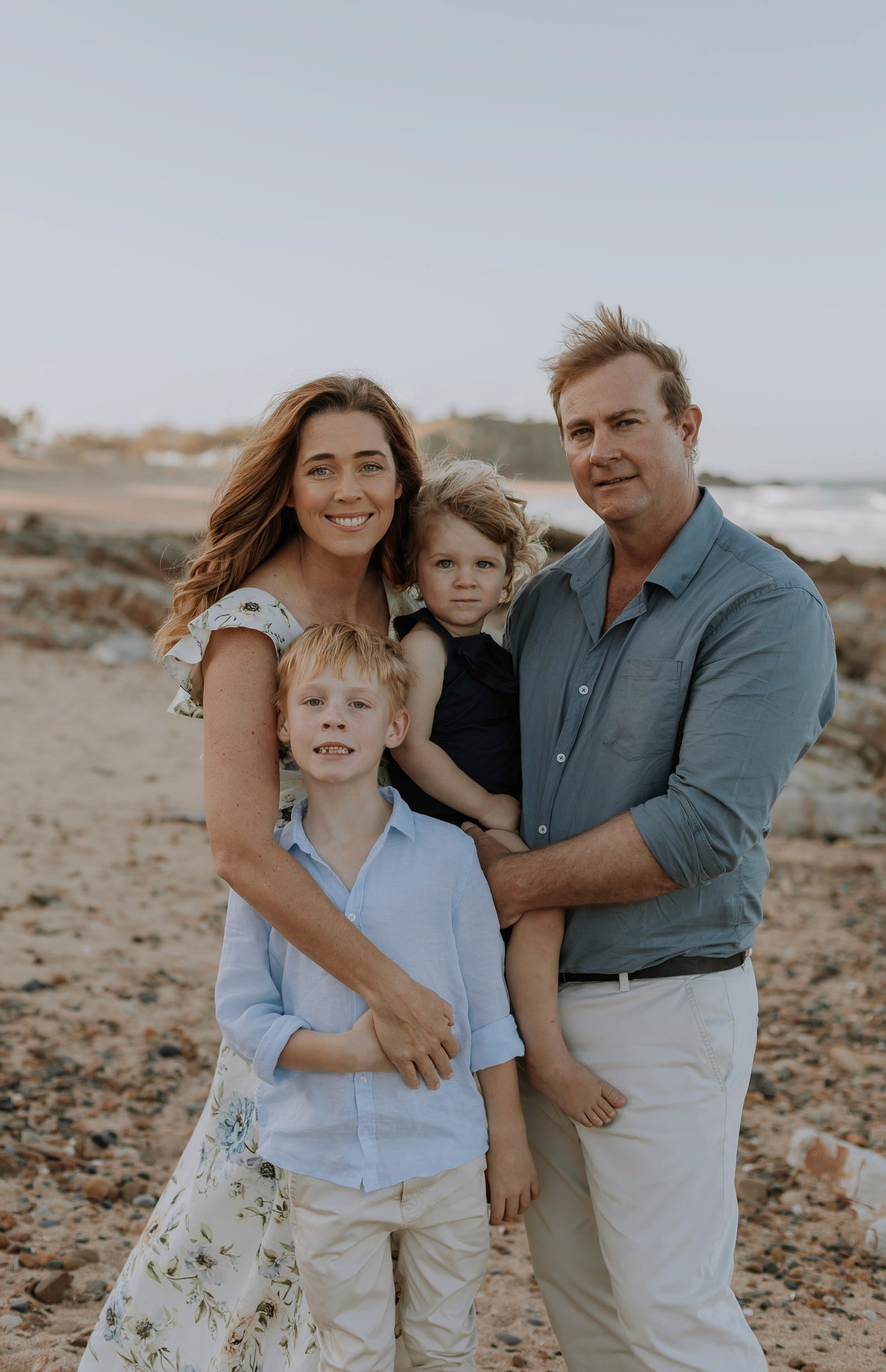 Family cuddling at the beach in Mackay