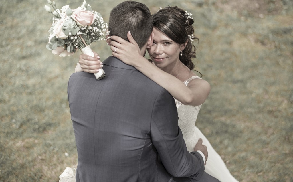 Tender embrace between bride and groom — a timeless fine art wedding portrait filled with quiet emotion. Tendre étreinte entre mariée et marié — portrait de mariage intemporel empreint d’une émotion silencieuse.