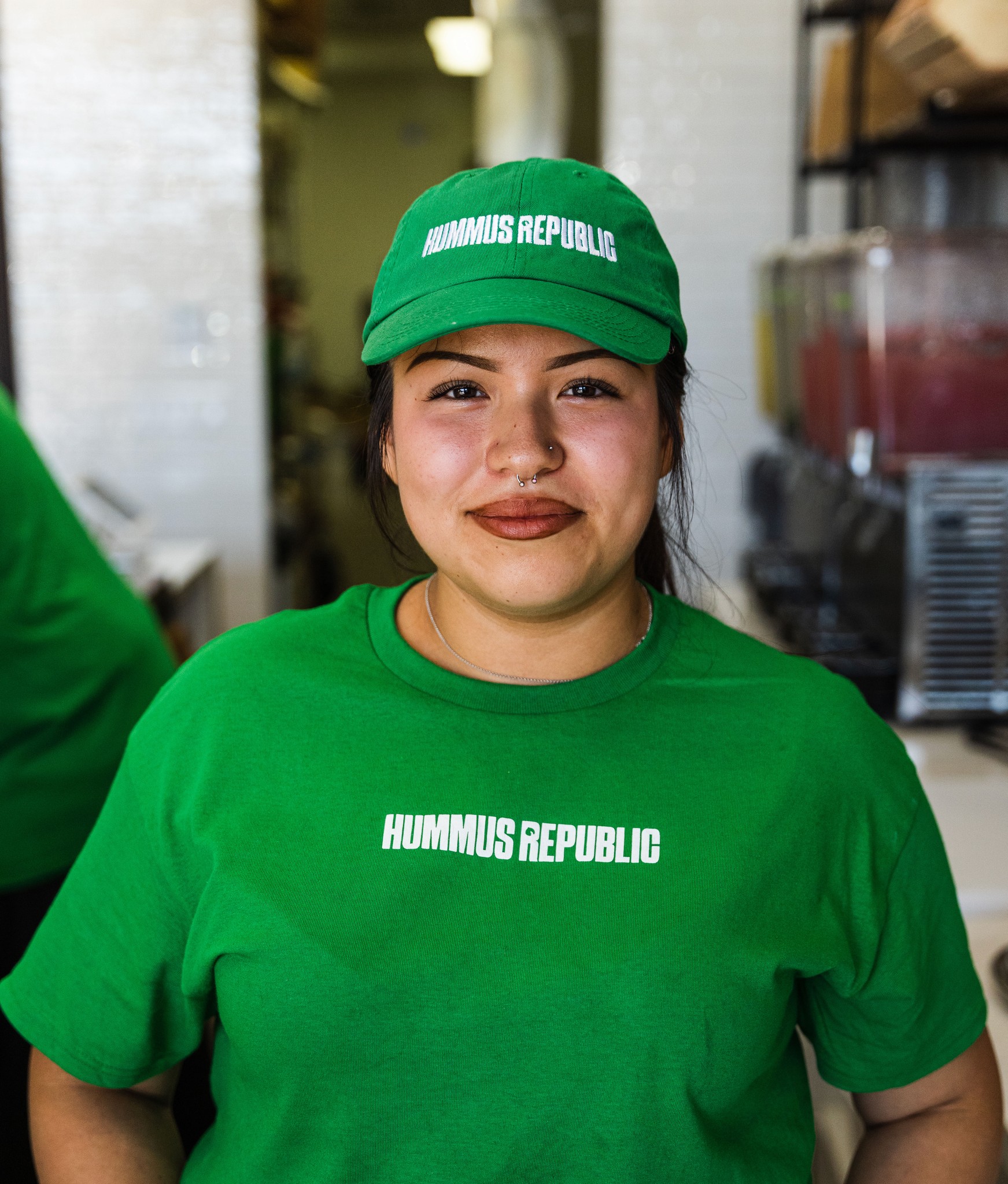Women with a green hummus republic hat and shirt