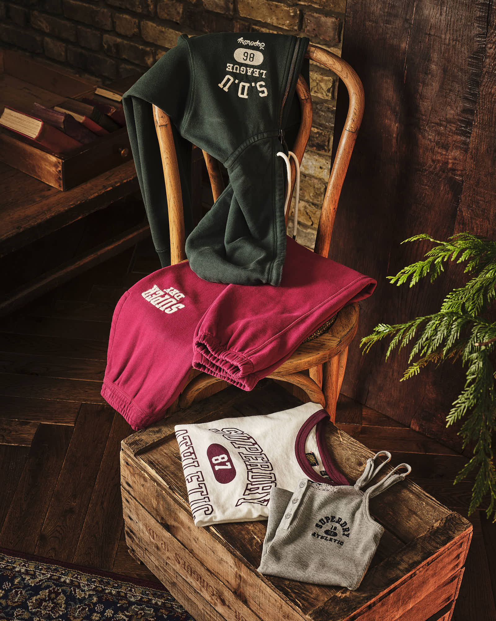 Cozy apparel ensemble featuring hoodie, joggers, and tops in rustic setting.