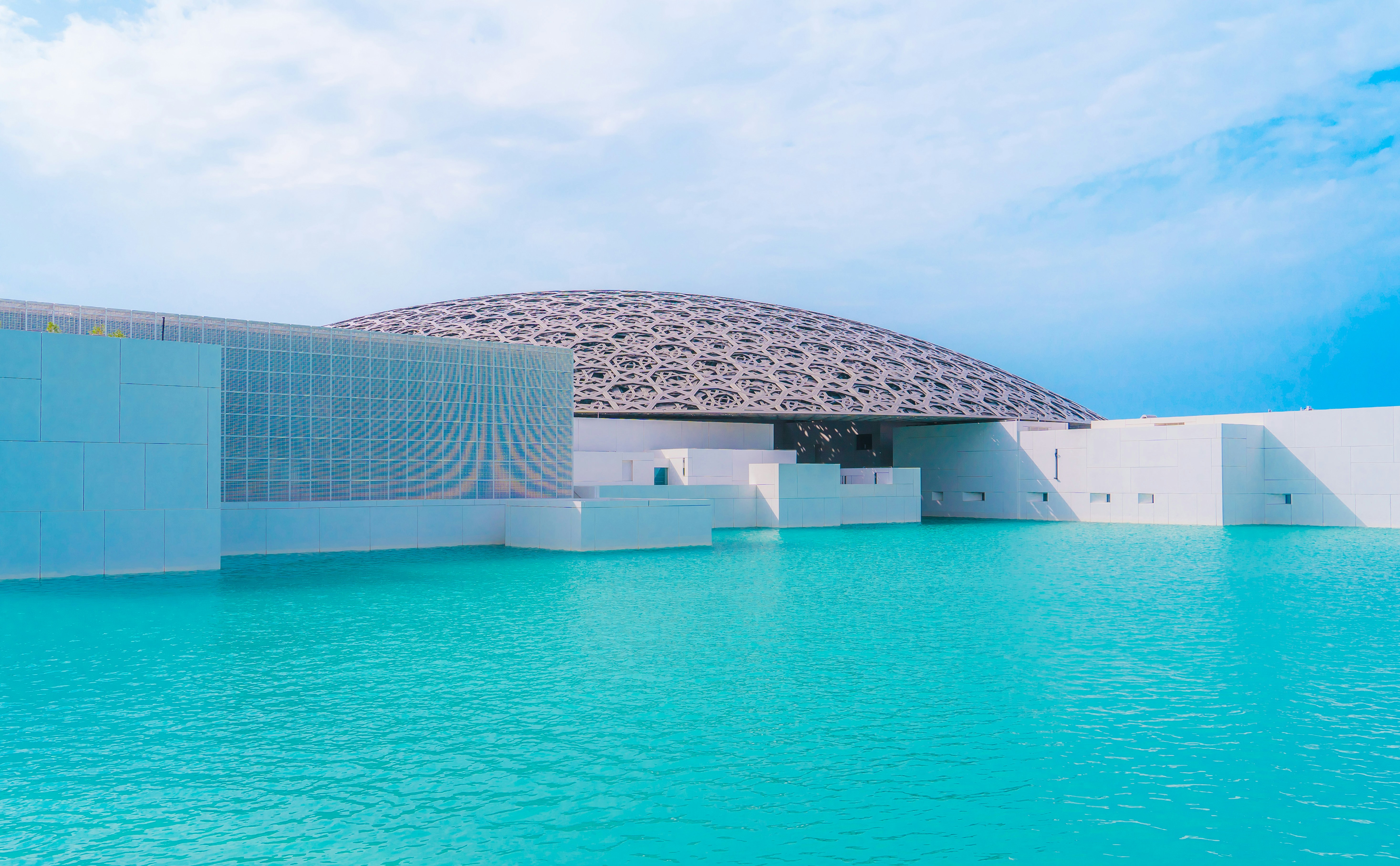 a large building with a dome on top of it next to a body of water