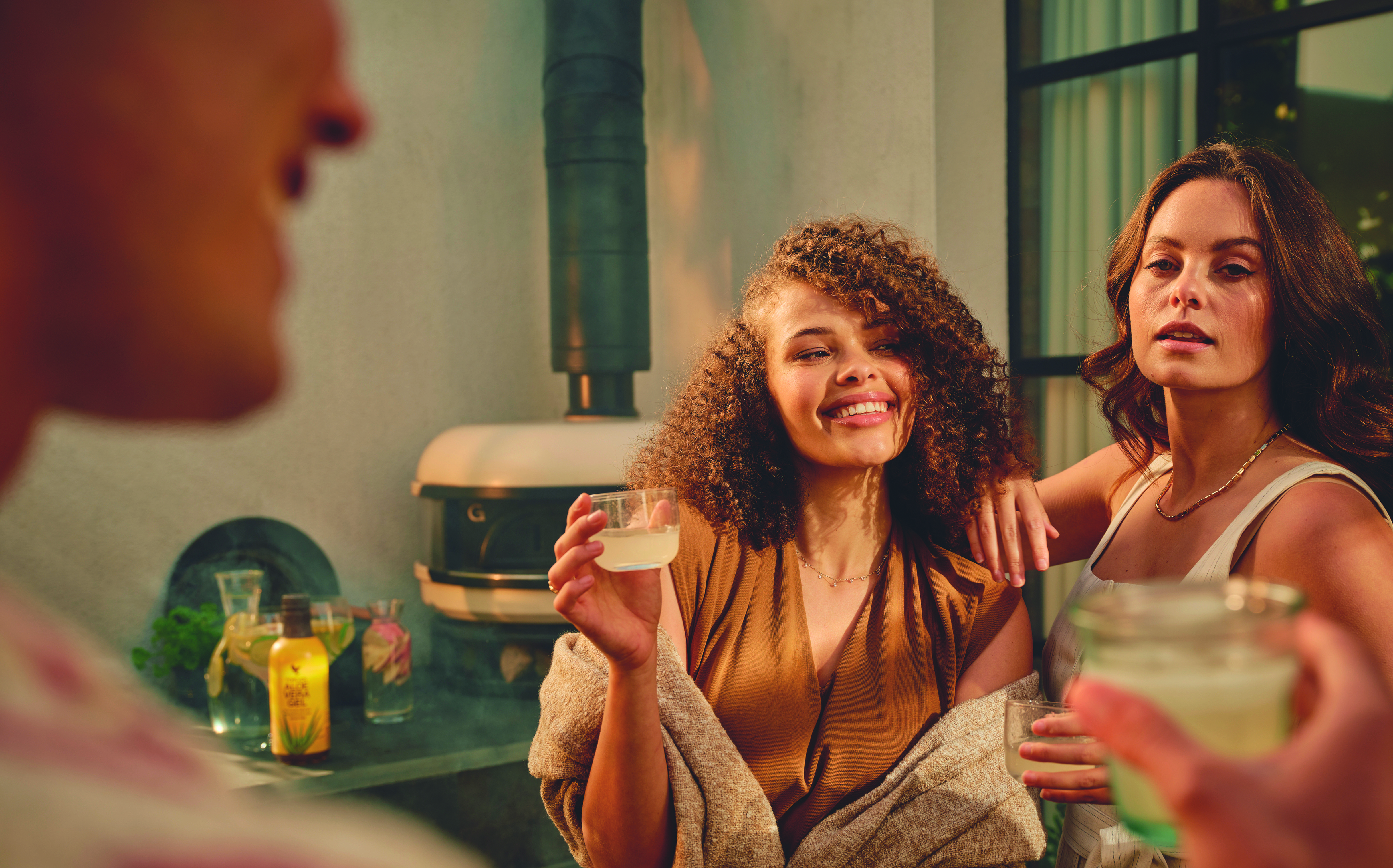 People socialising outdoors, holding drinks in a relaxed setting.