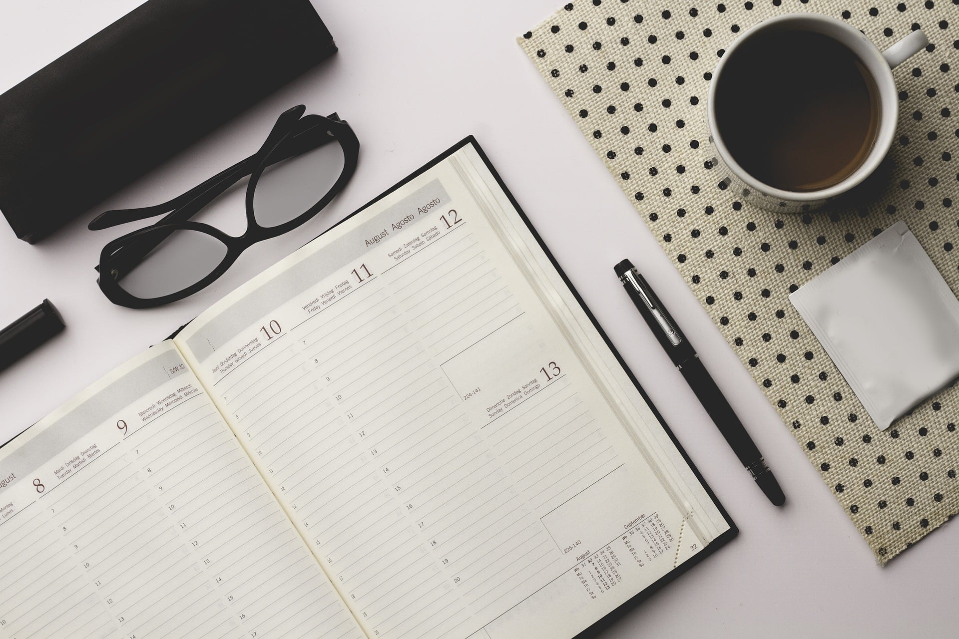 Calendar book, glasses, pen and coffee mug