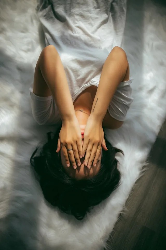 Person sitting on a bed in soft morning light