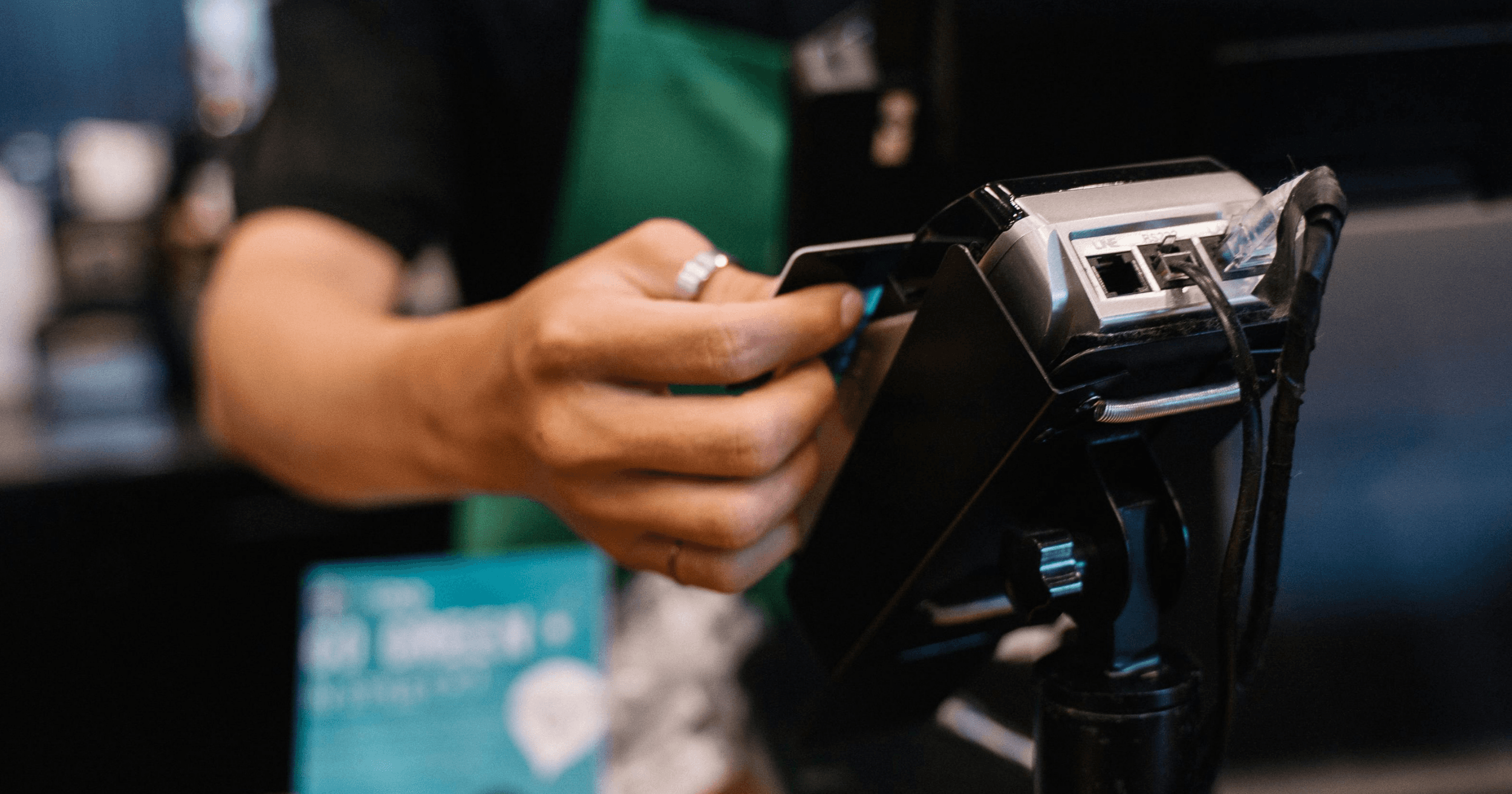 An F&B staff operating a card termnial and POS system