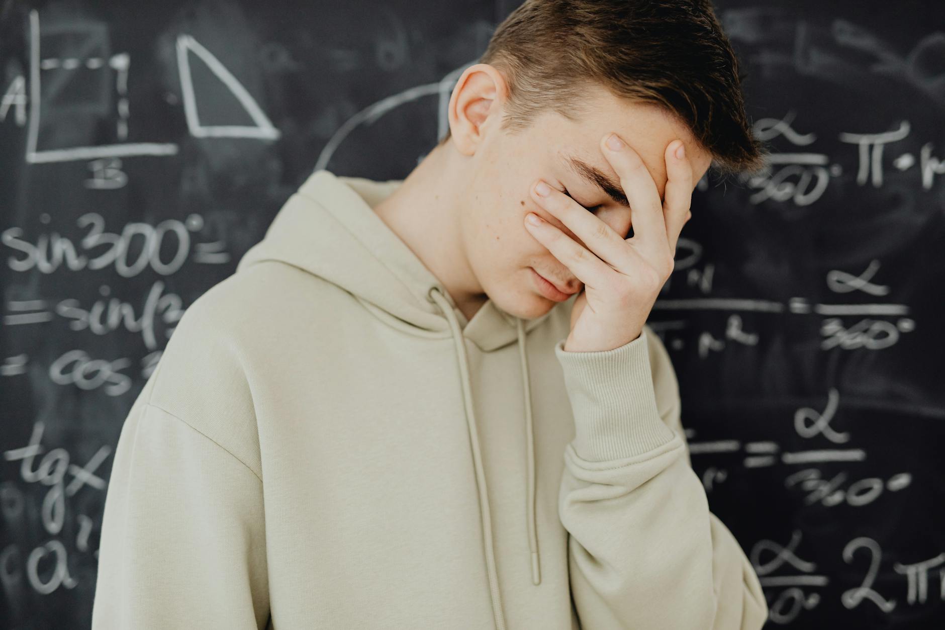 A frustrated student rests her chin on her hand while looking at a confusing diagram on a tablet screen.