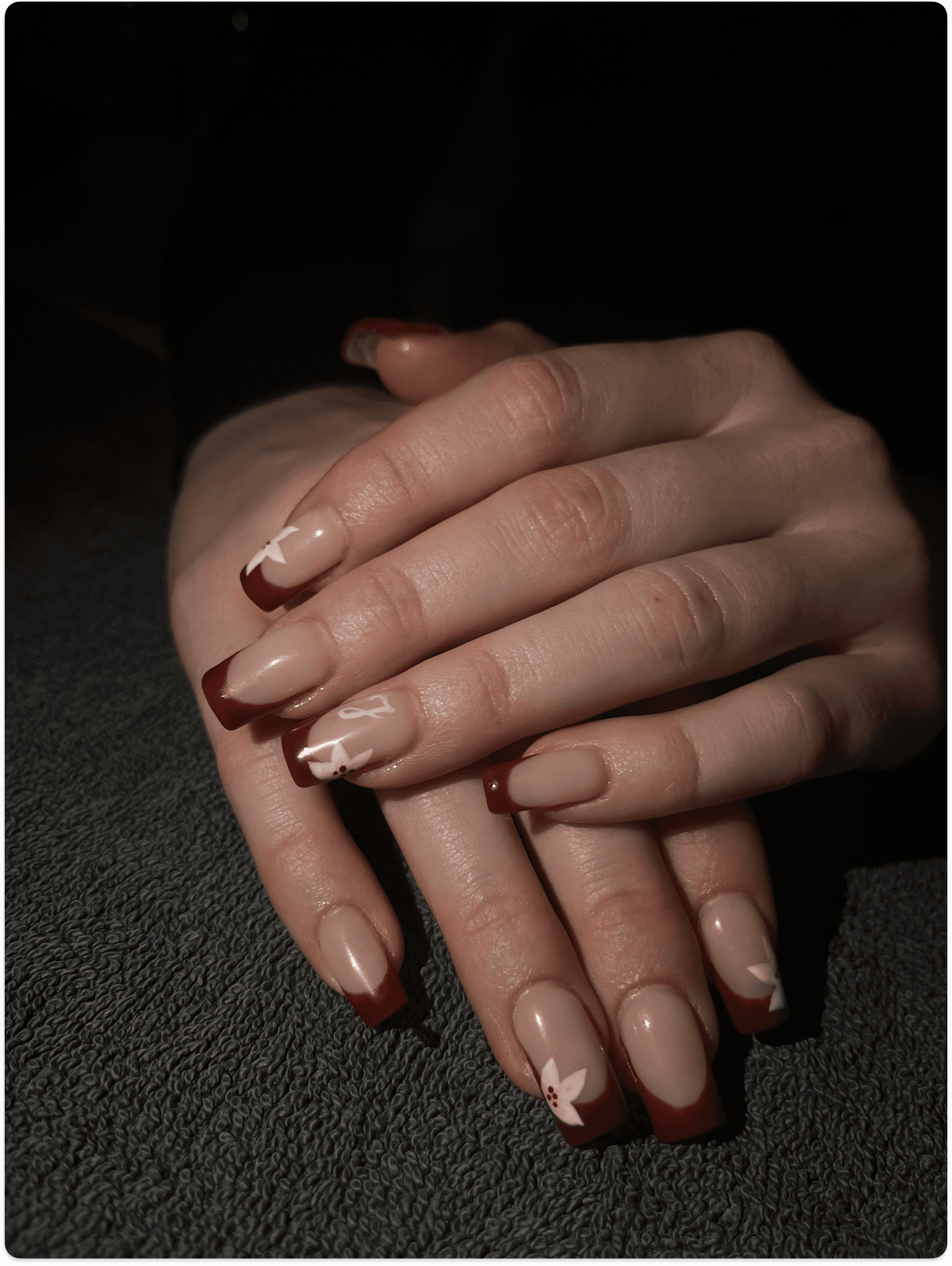 Hand with autumn-colored nails holding a brown purse