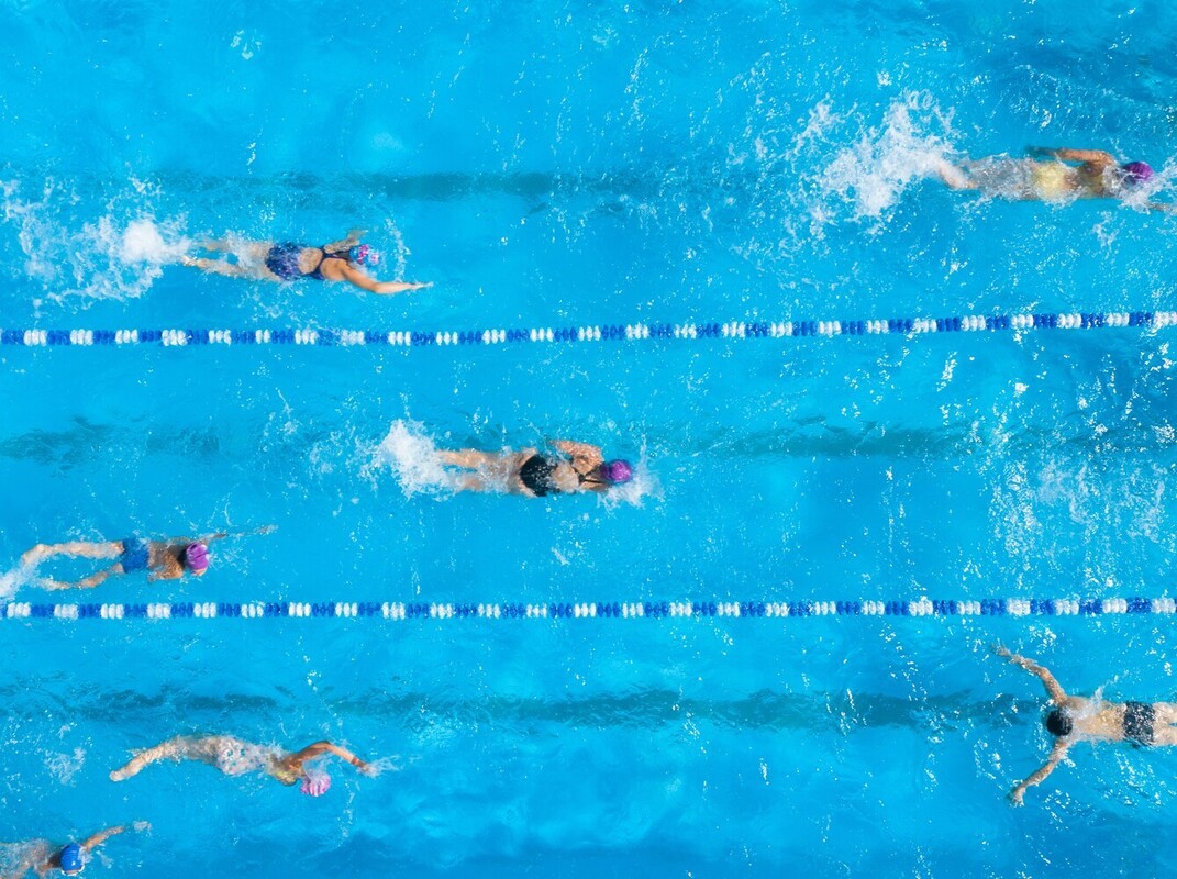 group of people doing their swim workouts to lose weight in a pool at the gym
