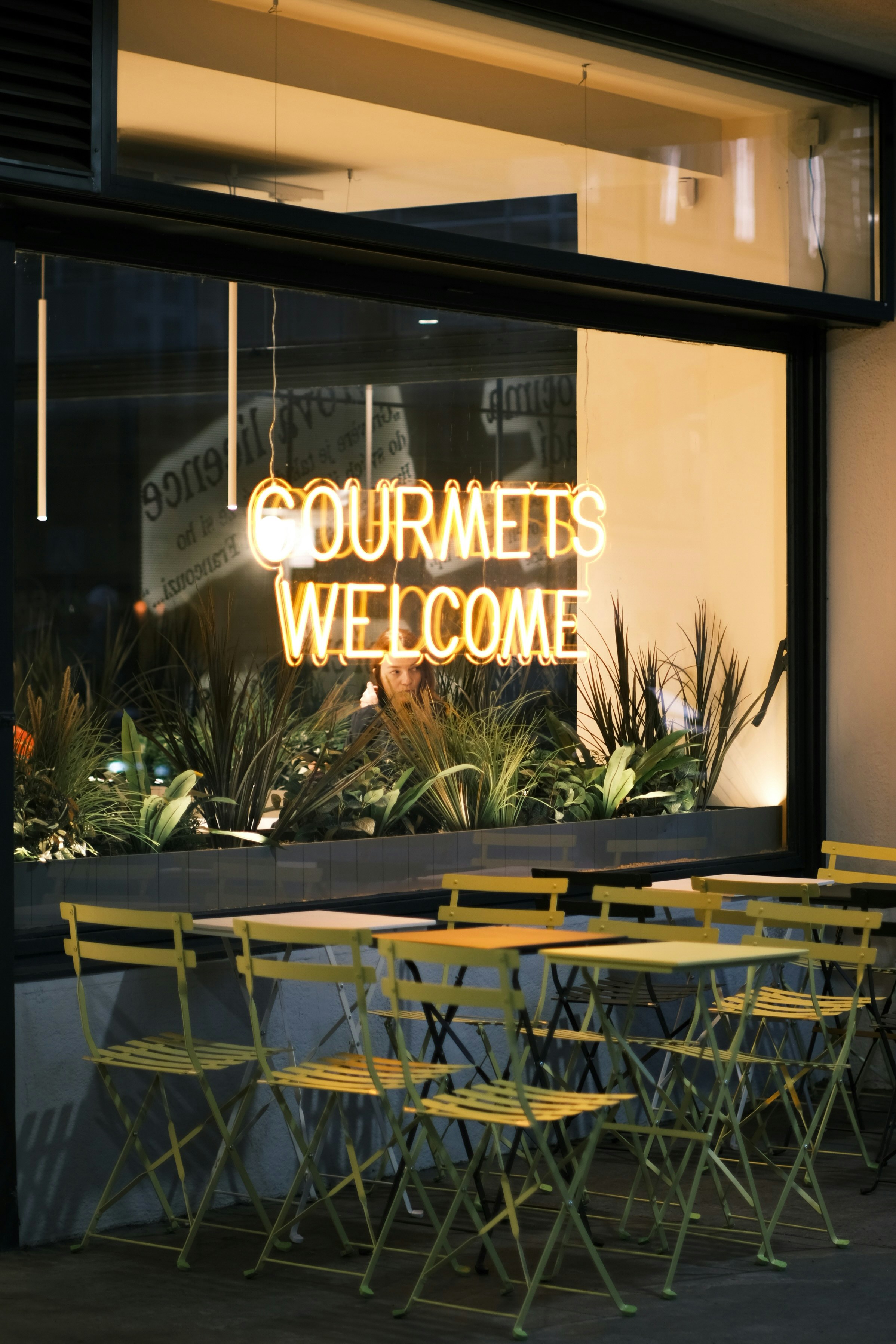 Outdoor cafe seating with neon sign
