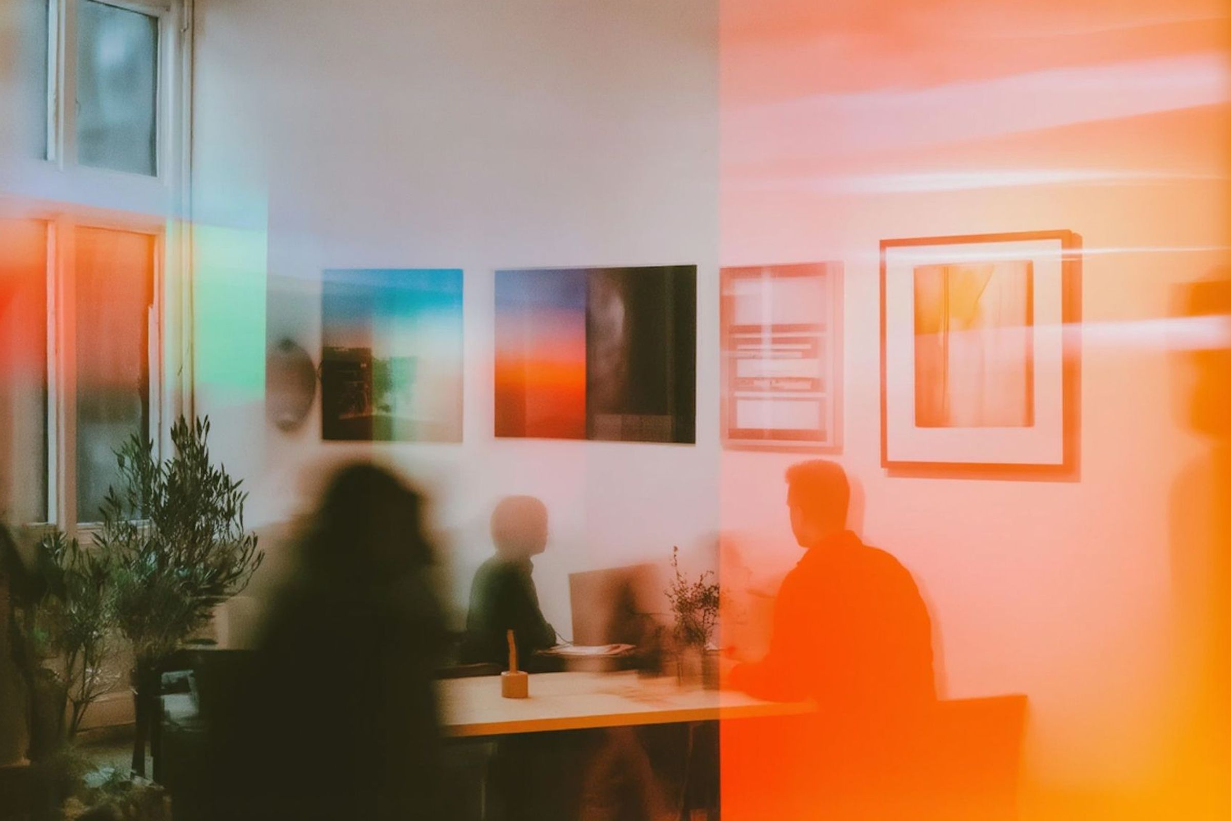 A warm-toned blurred office meeting scene.