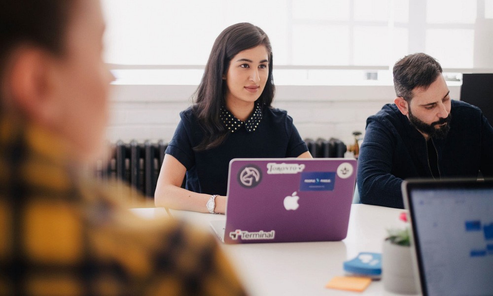A team sitting a front of their laptops  during a meeting 