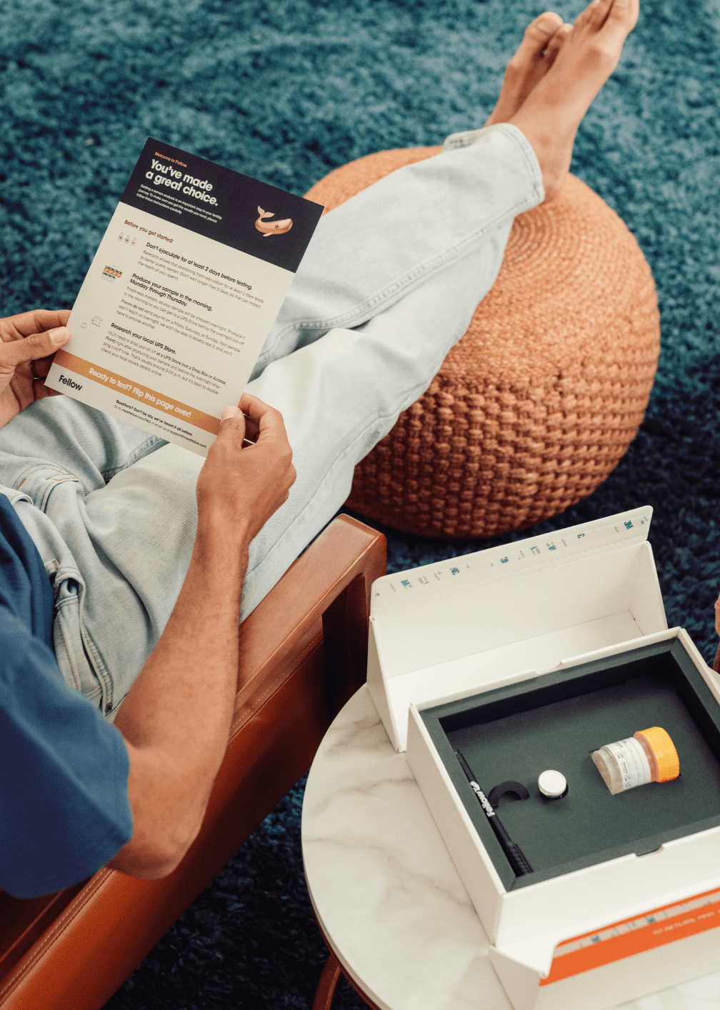 A man holds the FEllow Semen Analysis kit components and reads the instructions