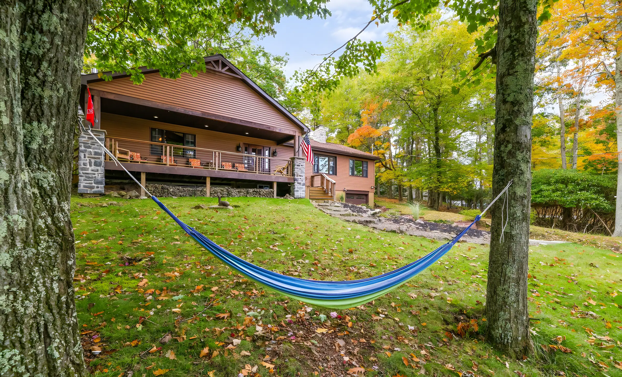 Brown chalet with large covered porch and hammock on the front lawn at Laketop Lodge, Lake Harmony, PA