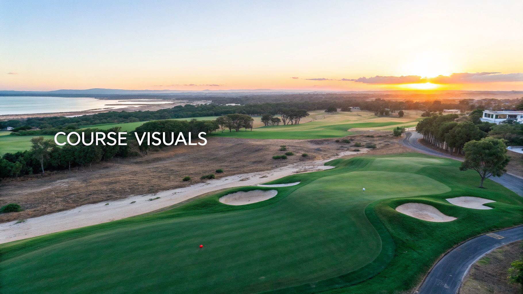 Aerial view of a beautiful golf course at sunset with lush green fairways, sand traps, and water.