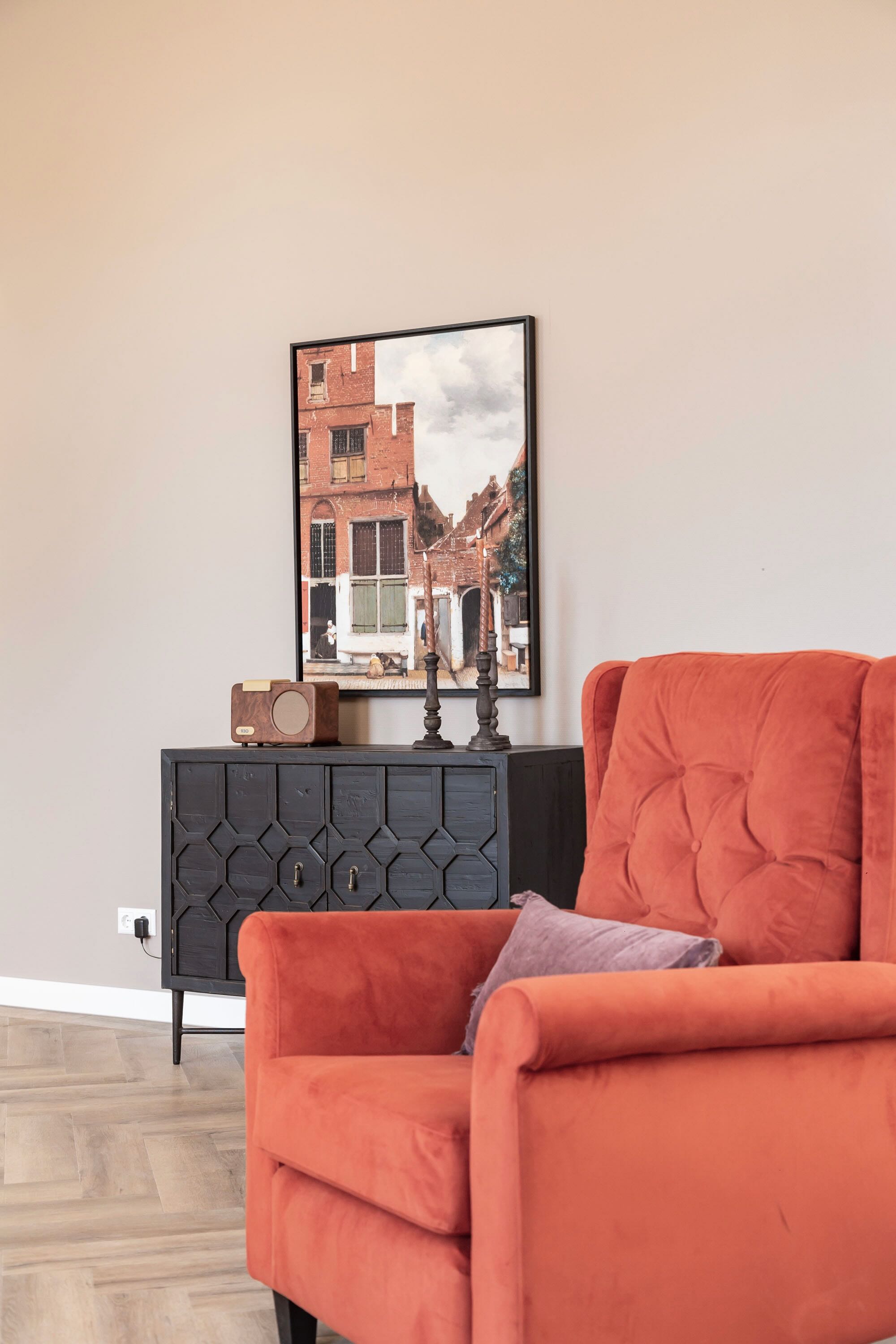 oranje, terracotta fauteuil met oude meester schilderij huisjes