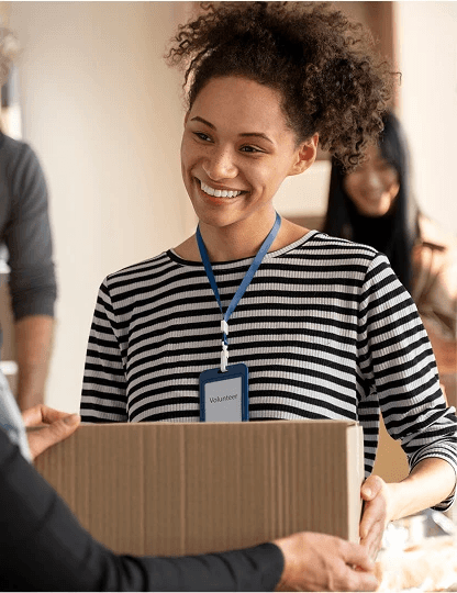 Professional woman in a striped shirt with a lanyard, smiling in an office environment.