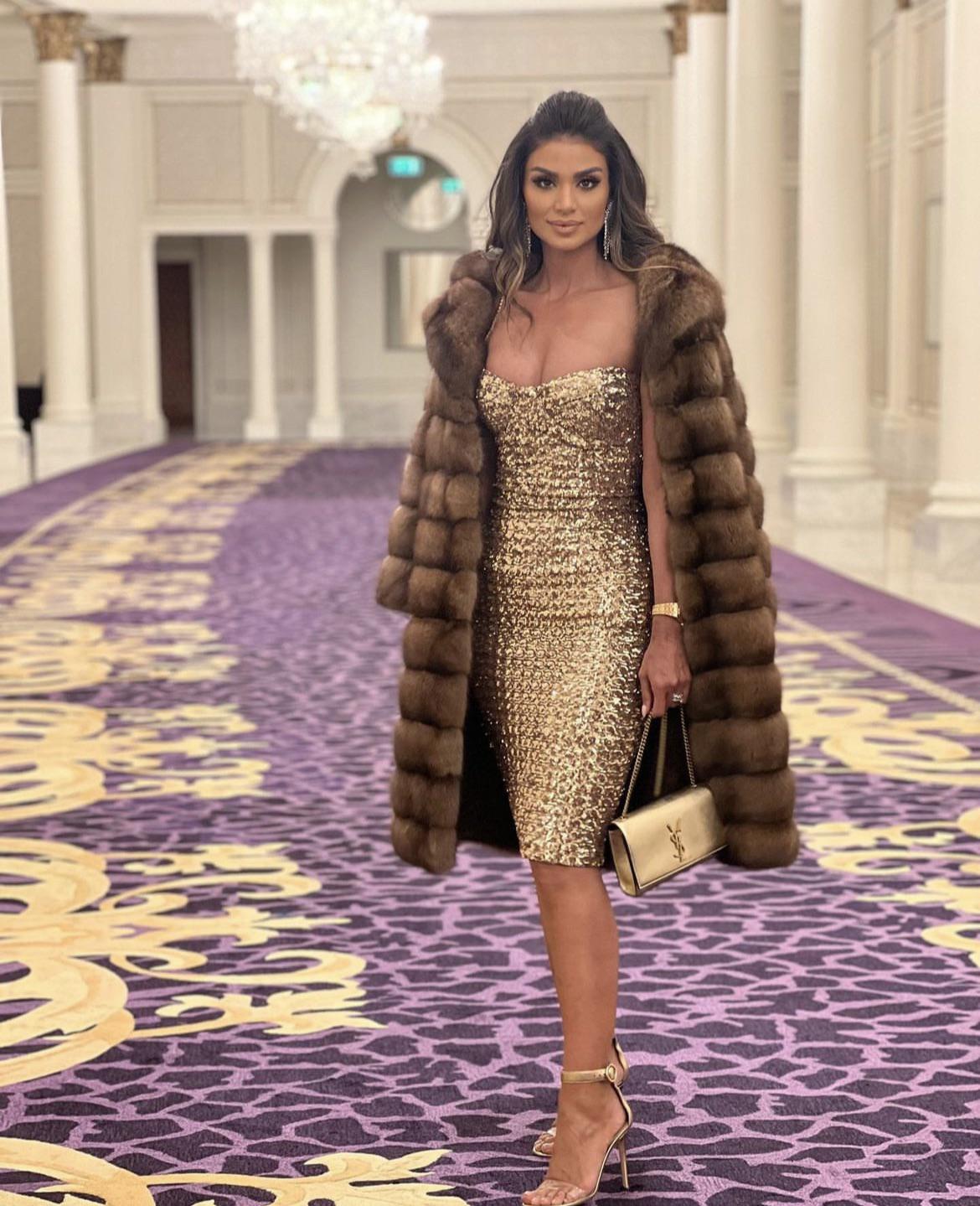 Black-and-white party photo of a smiling man in a check blazer among a crowd.