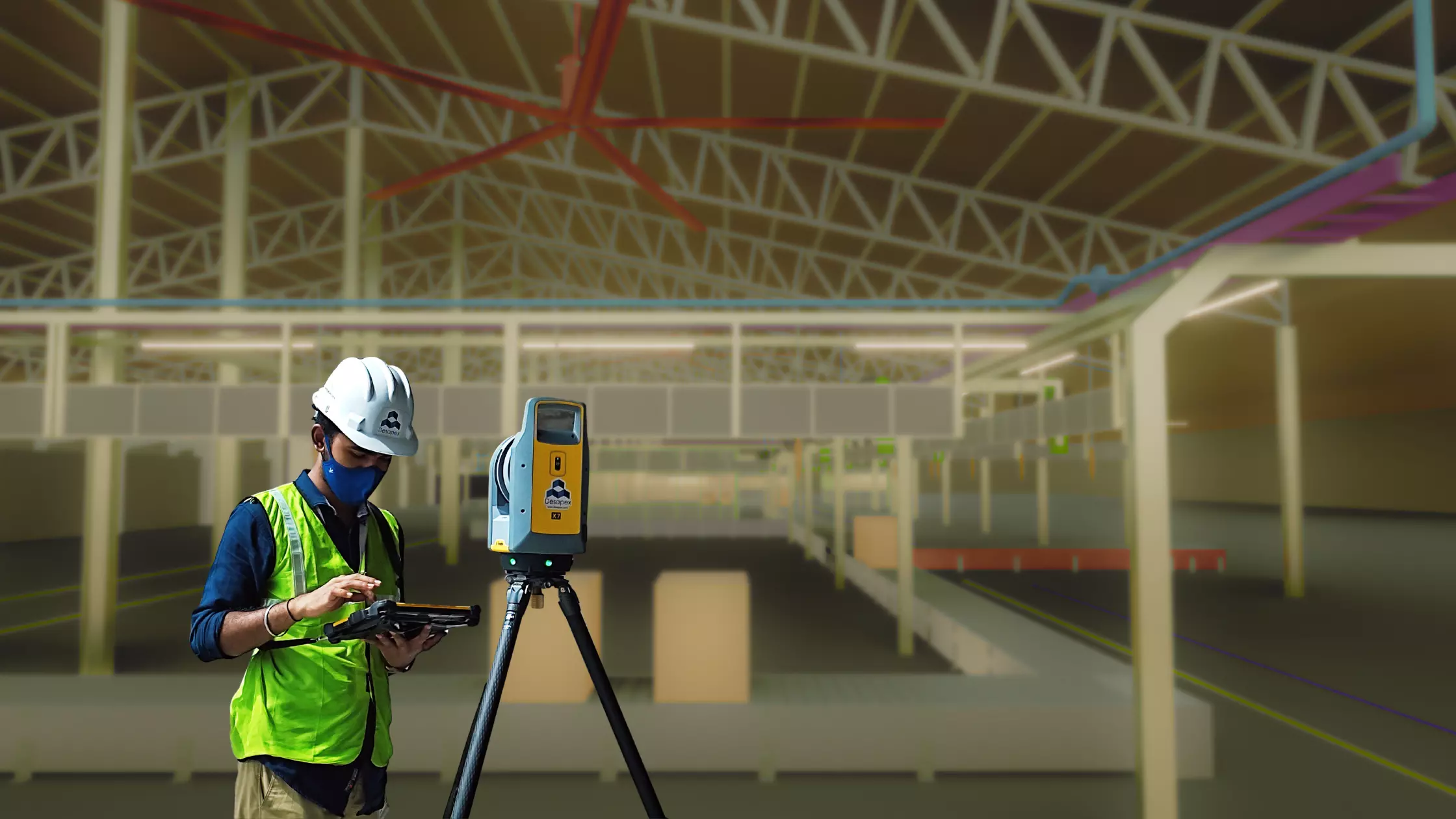 A man stands while two people sit at a table in an office setting, smiling and engaged in conversation. The mood is friendly and collaborative.