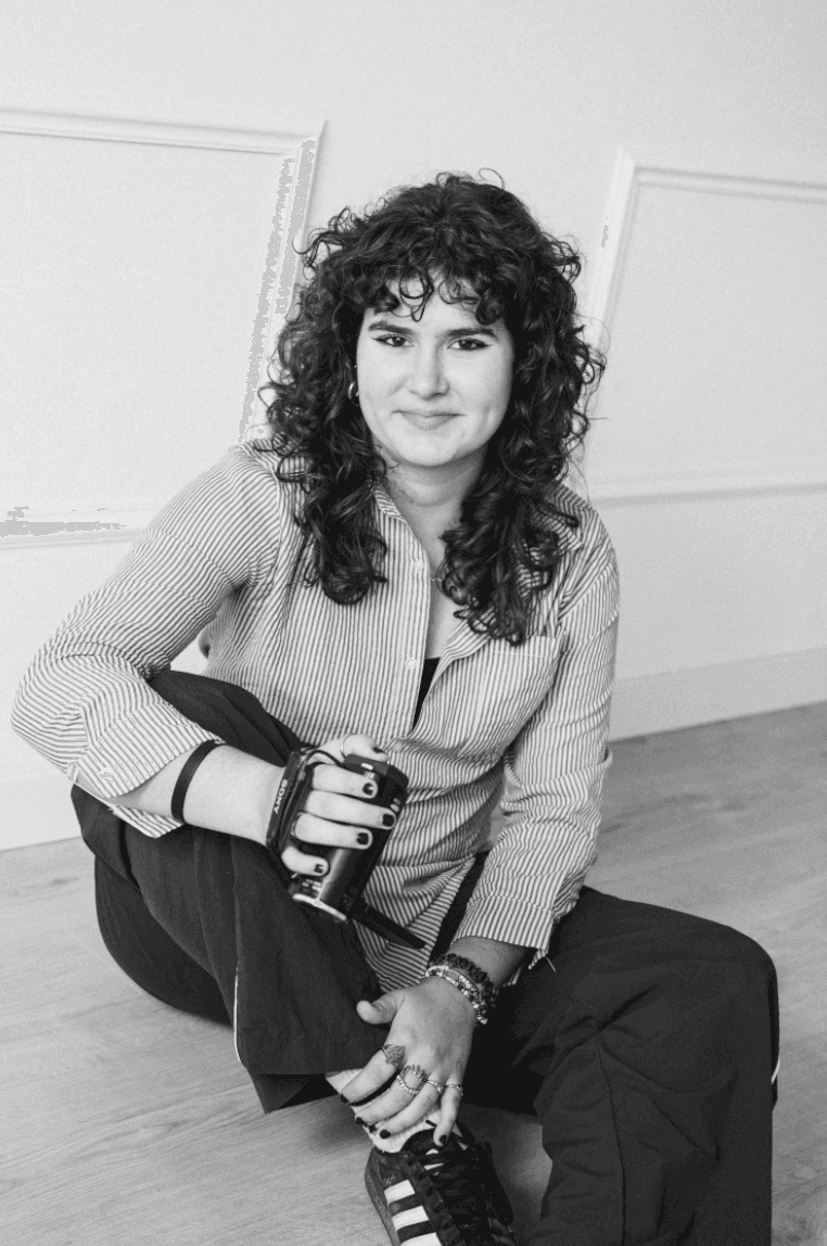 Portrait of a laughing person with curly hair wearing a white shirt