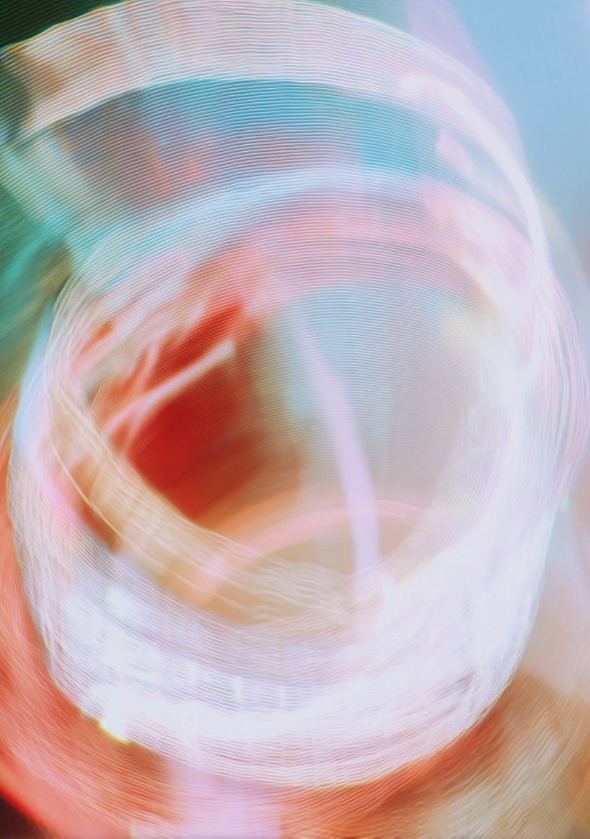 A vibrant abstract image featuring swirling bands of light in hues of pink, red, and blue, creating a dynamic and energetic visual effect.