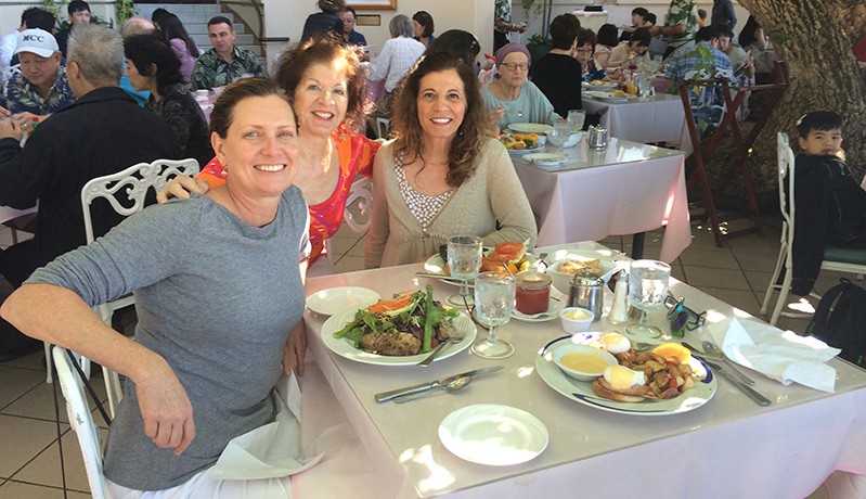 A photo of three women sitting at a restaurant table.