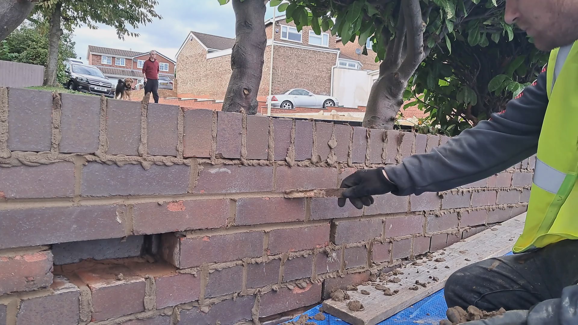 A man finishing joints on a garden wall