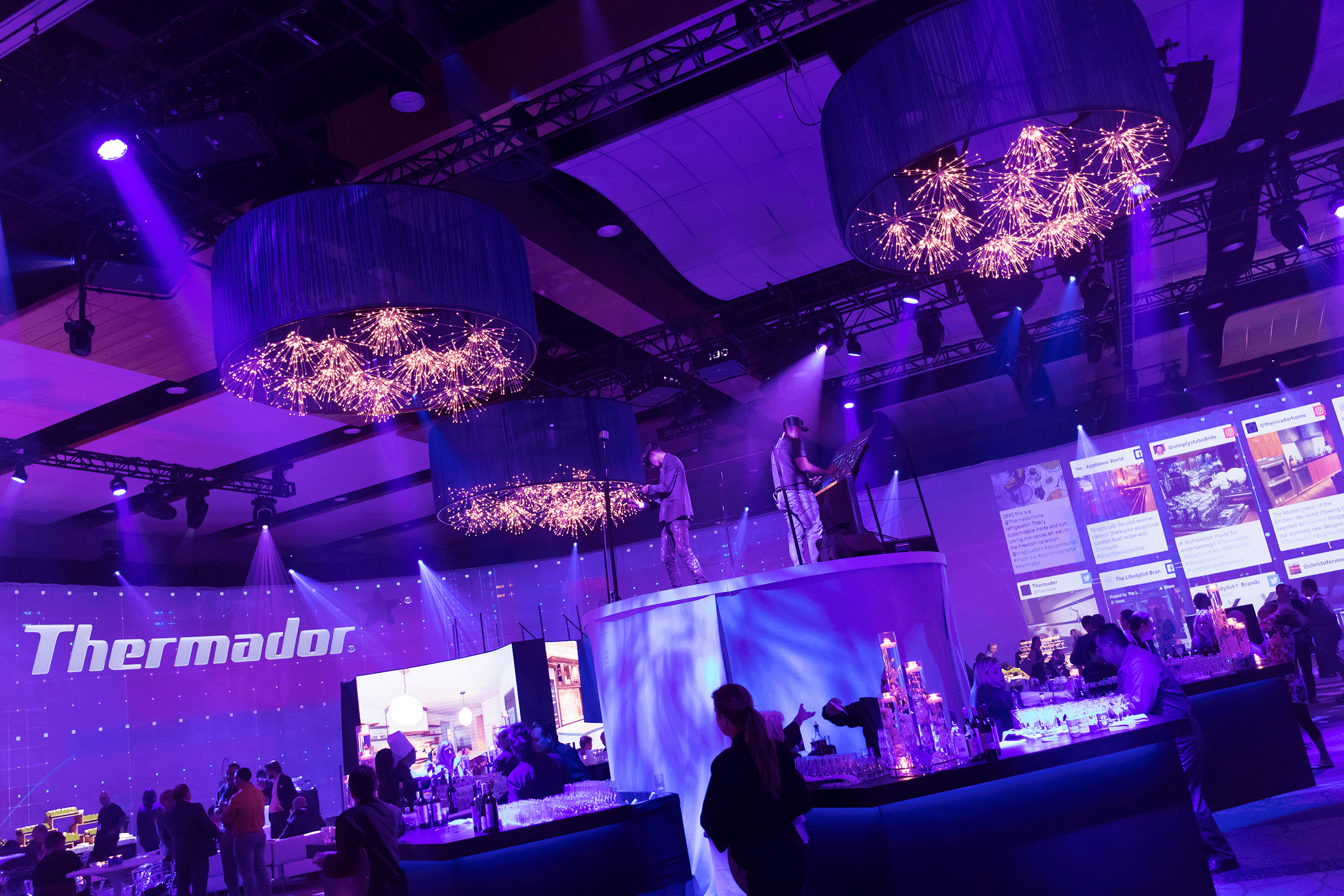 Thermador ballroom with center stage with perfomers wearing headgear painting in virtual real time