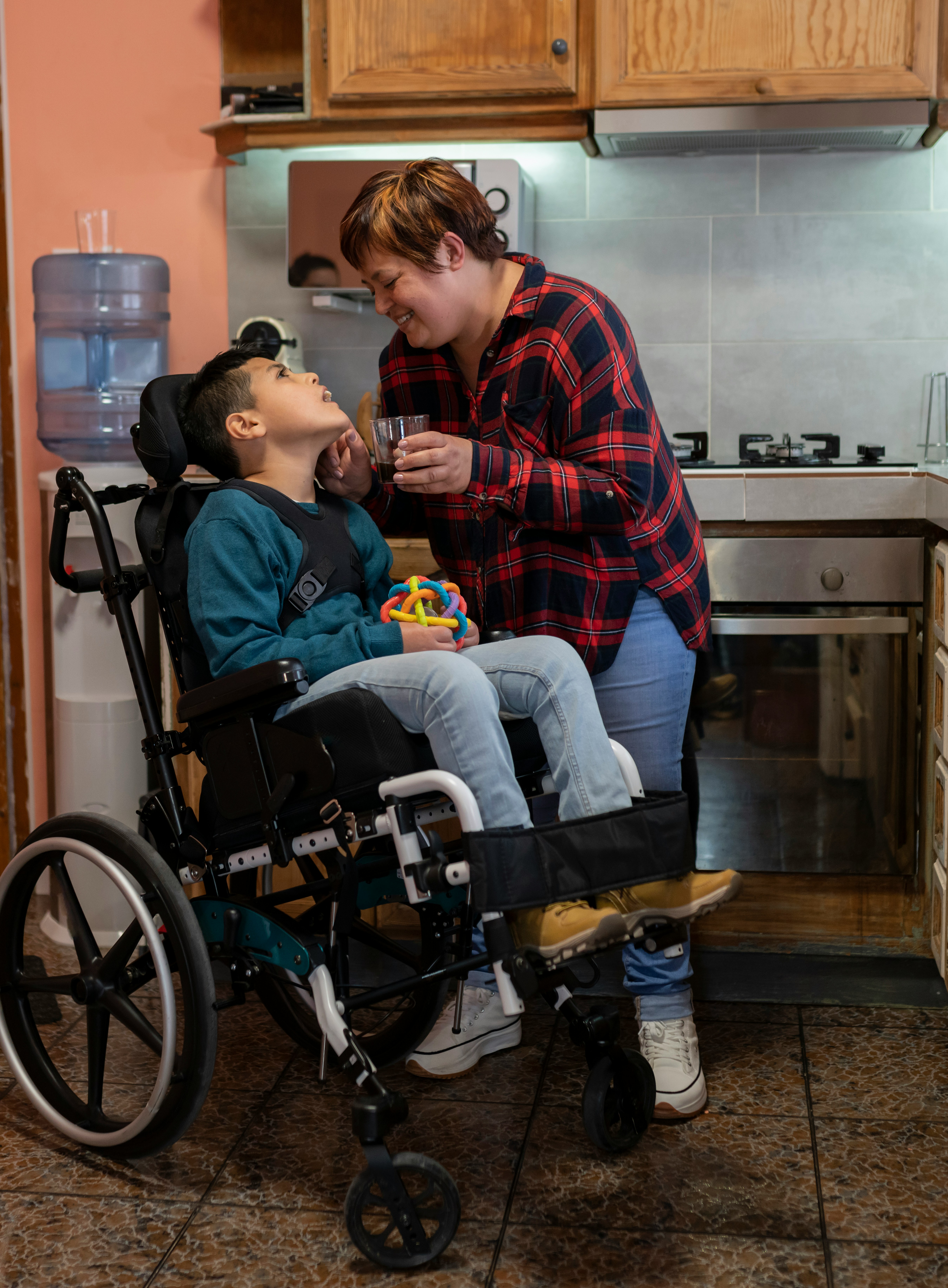Disable child in wheel chair being taken care of by his mother. 