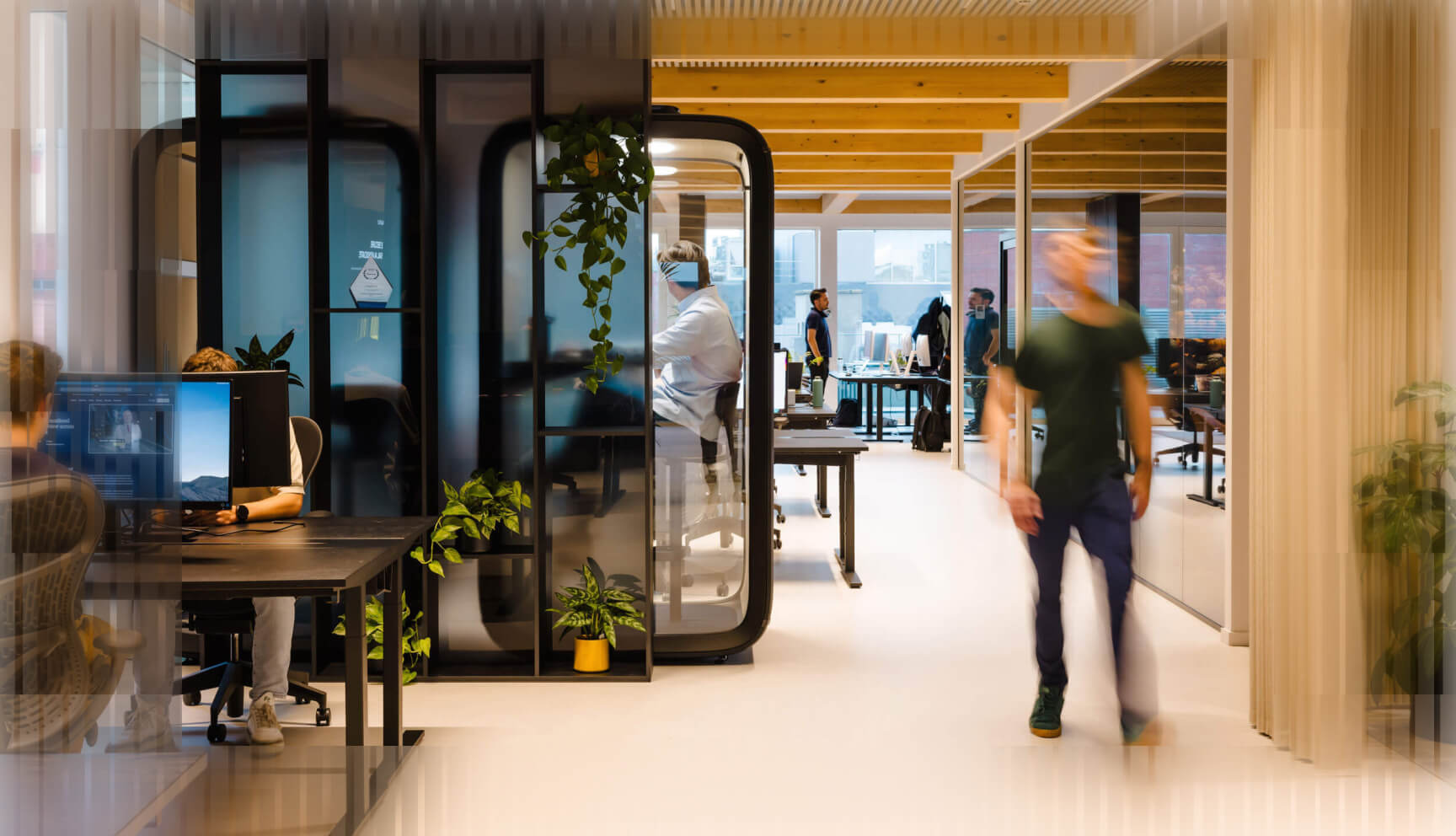 Black and white image of people working at a table with laptops, showing hands gesturing during discussion of digital content displayed on screens, with fabrica® logo in the corner.
