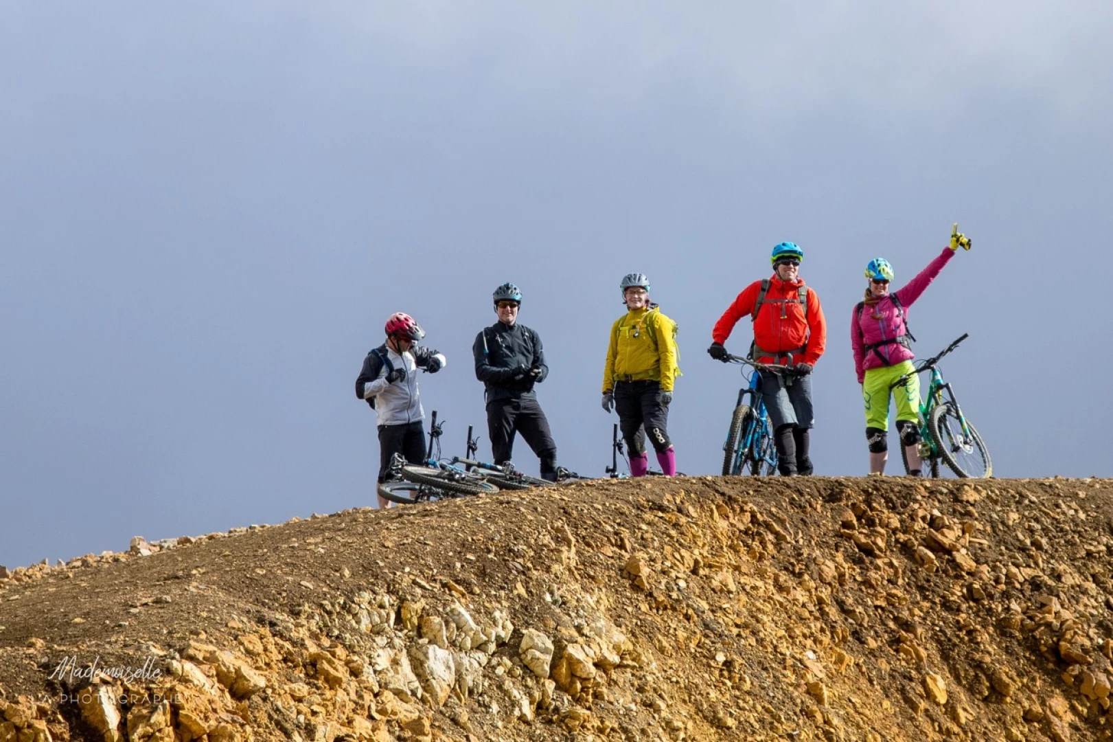 Five people stand on a mountaintop on a biketour