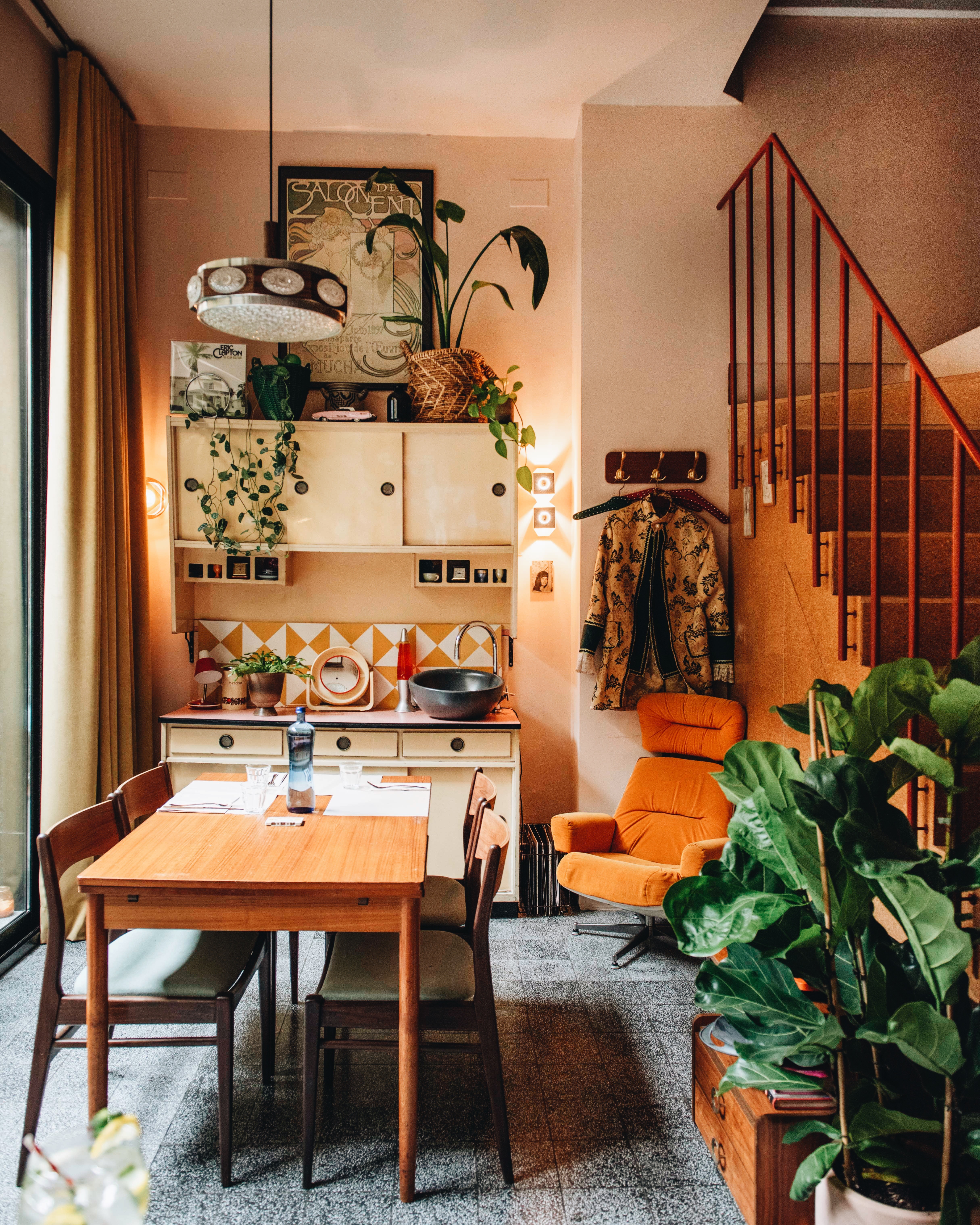 Retro interior with vintage furniture and plants at Faire. Brunch & Drinks, Eixample