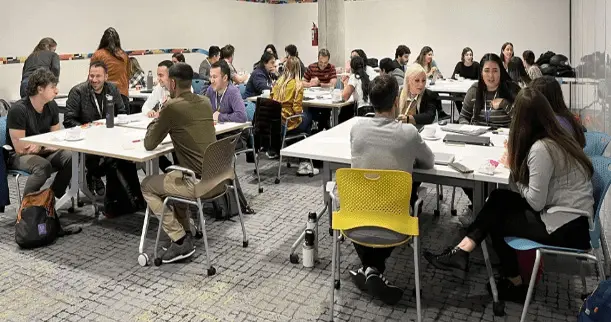 Muchas personas sentadas trabajando en equipo